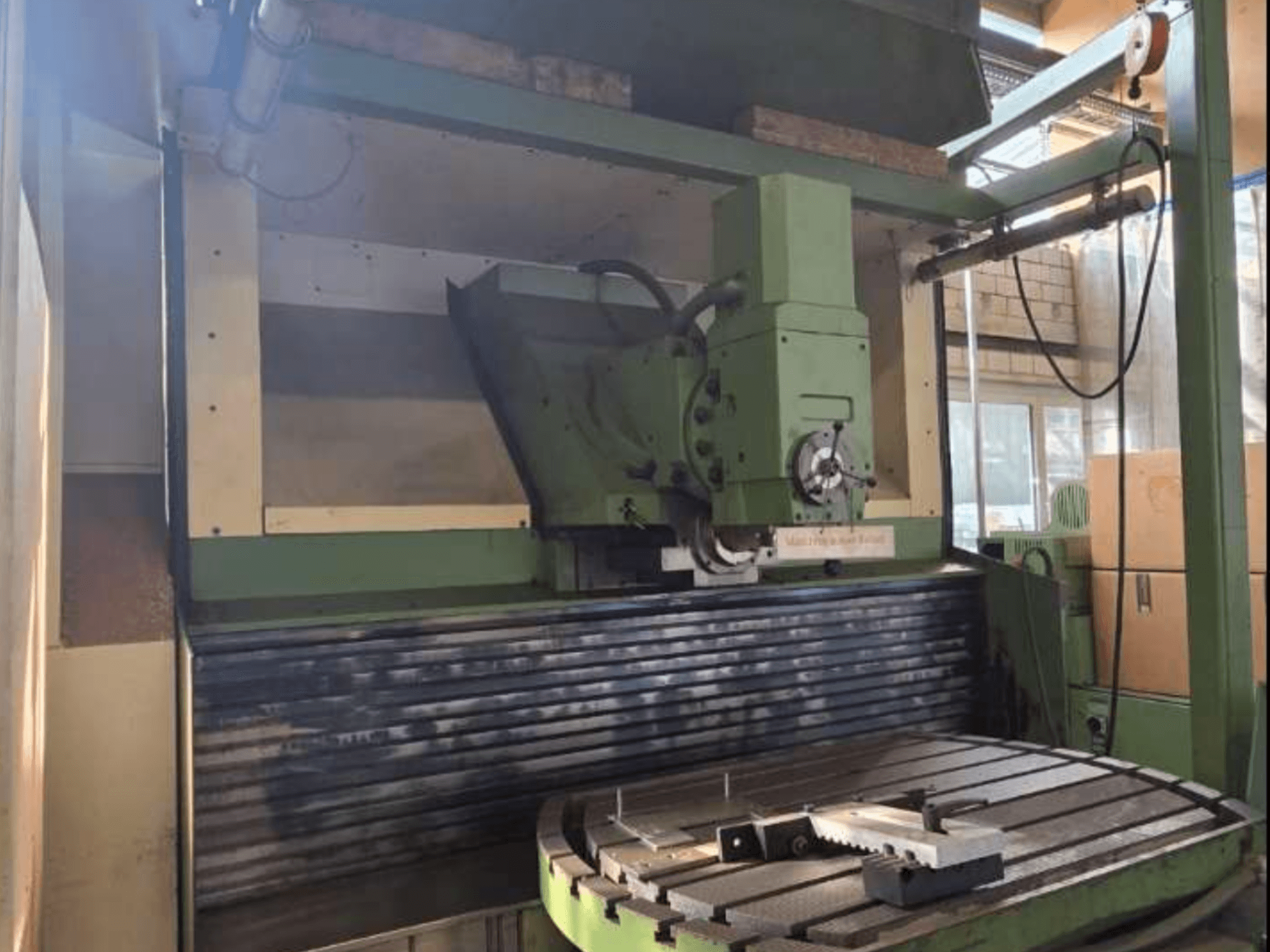 MAHO MH1000 C universaaltöötluskeskuse esiplaanil, kus on näha rohelist konstruktsiooni, spindlit ja pöörlevat lauda koos toorikuga.