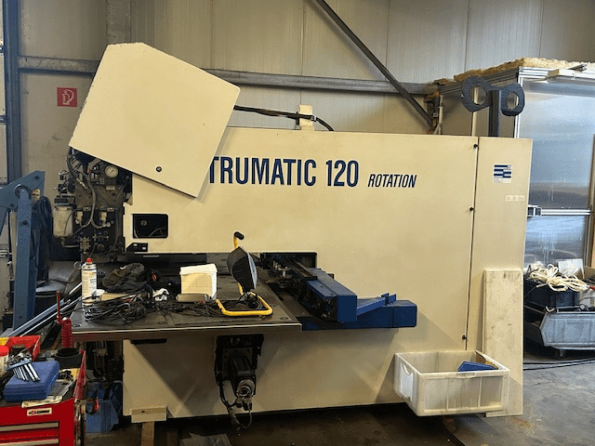 TRUMPF Trumatic 120R CNC-stantsimismasin töökojas, esiplaanil on juhtpaneel ja tööriistad laual.