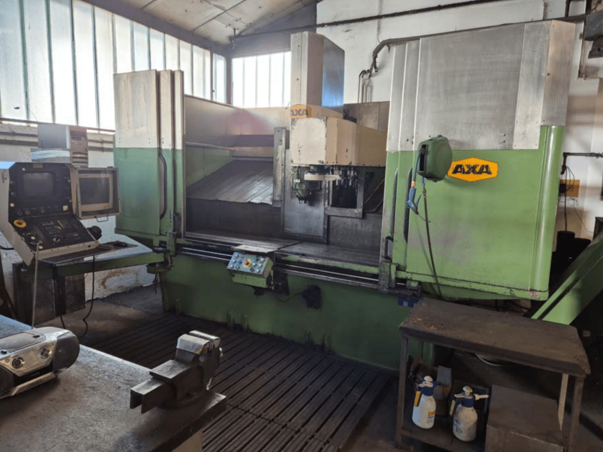 AXA VSC-2M vertikaalne töötluskeskus, esiplaan, juhtpaneel ja tööala koos lõiketööriistade ja puhastusvahenditega.