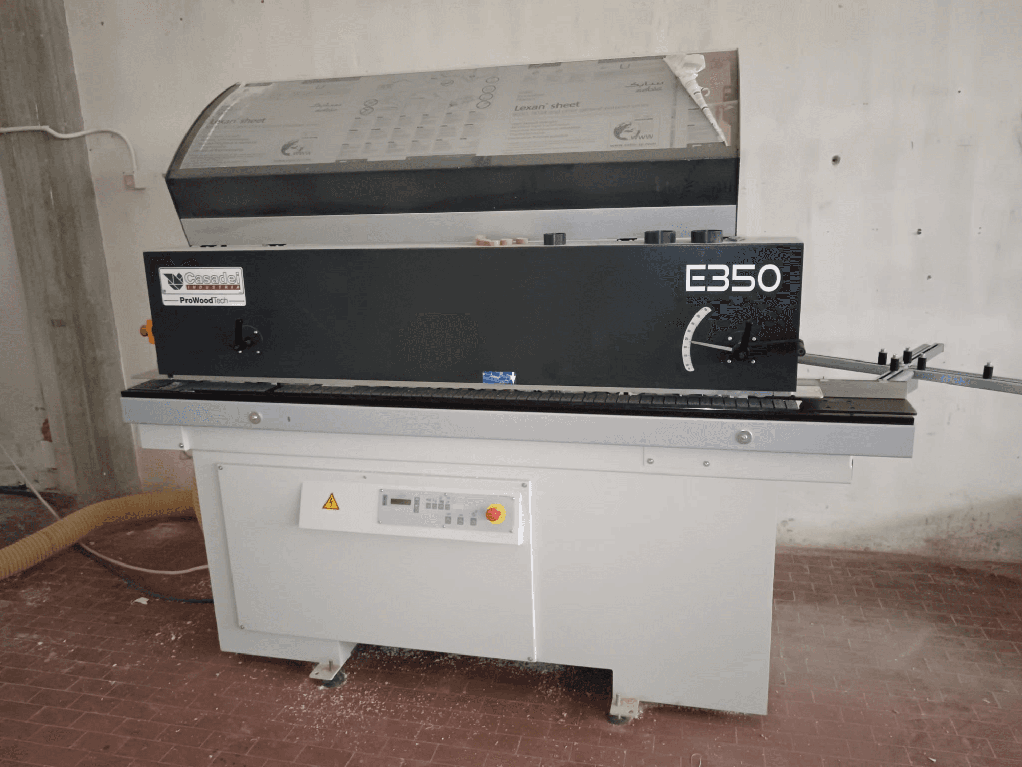 Cesaroli ProWoodtech E350, külgvaade puidutöötlusmasinast koos juhtpaneeli ja tolmu kogumisega, paigaldatud valgele alusele.