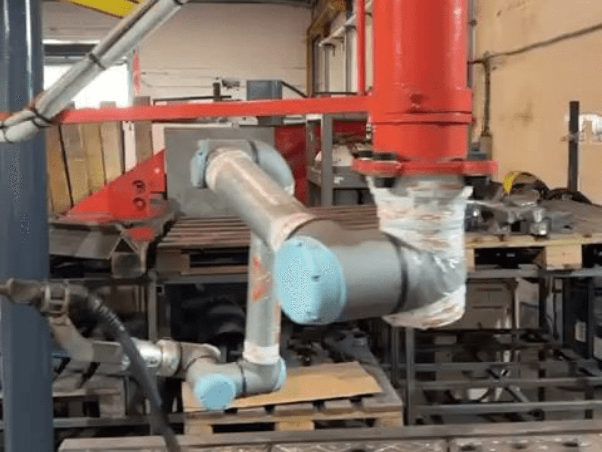 Universal Robotsi koostöörobot UR10e töökodas; külgvaade, millel on näha käe ja liigeste liikumist masinate lähedal.
