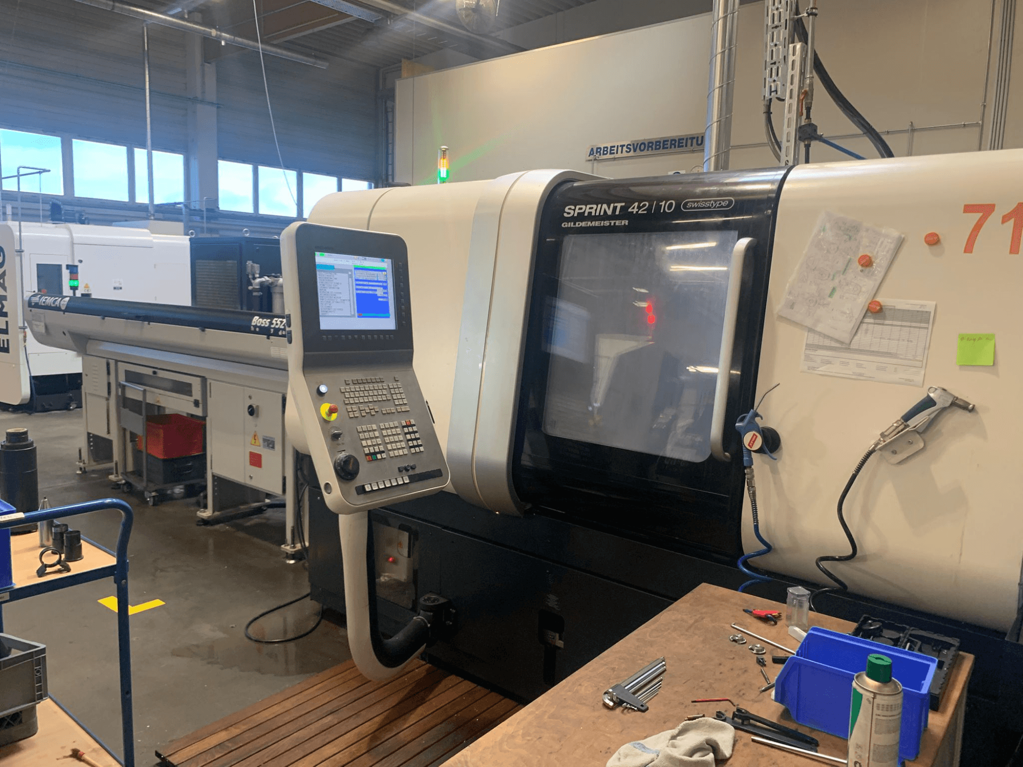 DMG MORI Sprint 42/10 lineaarne Šveitsi tüüpi treipingi, esiplaanil, millel on juhtpaneel ja tööruumi segadus.