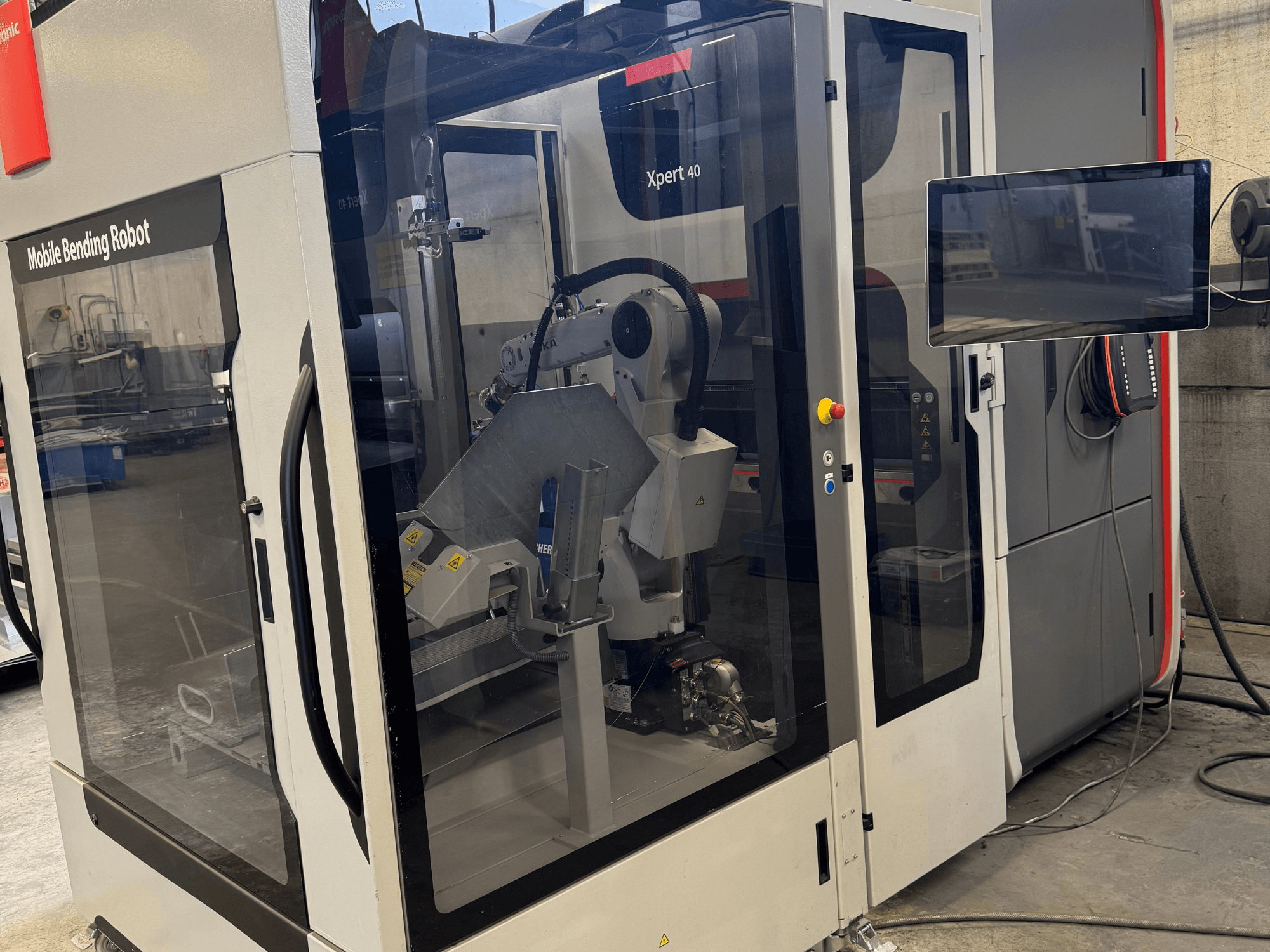 Bystronic Xpert 40/1030 presspink koos mobiilse painutusrobotiga, esiplaanil on juhtpaneel ja roboti komponendid.