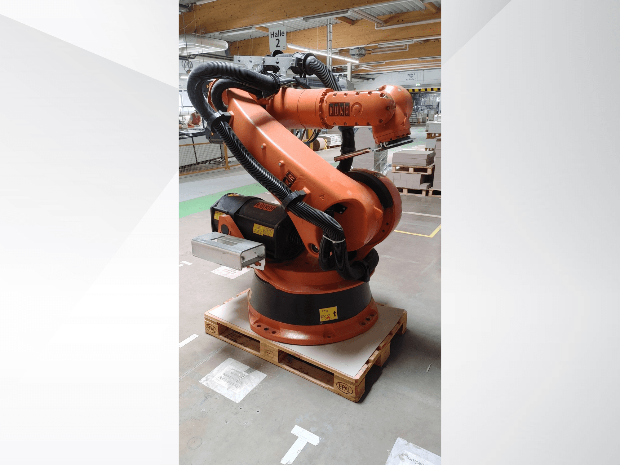 KUKA KR140-3 COMP robotkäsi oranži värvi, esivaade puidust kaubaalusel, kaardus käe ja juhtimiskarbiga.
