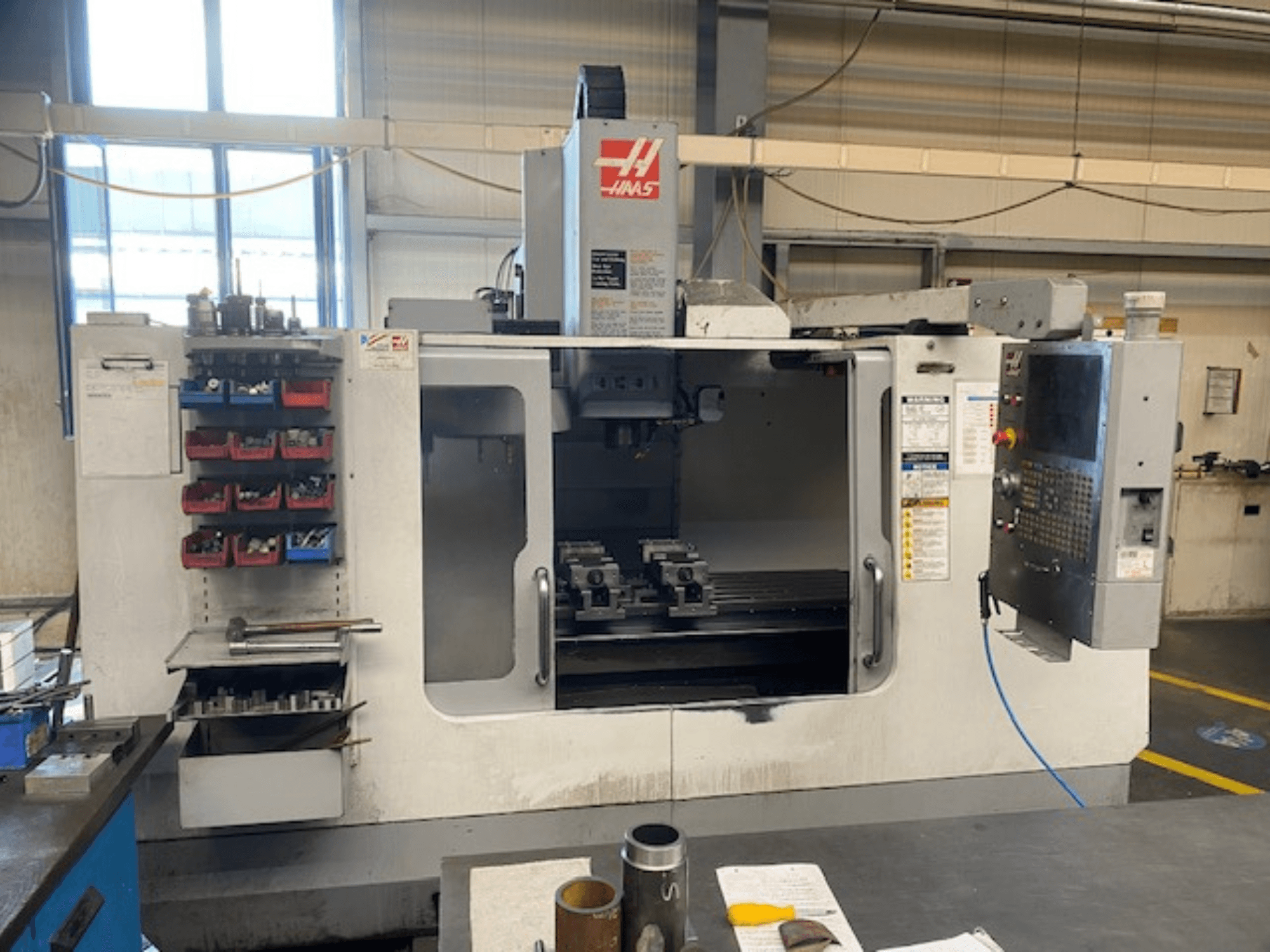 Haasi CNC-freespingi esivaade, mudel VF-2, kus on näha tööriistade hoidla, juhtpaneel ja tööruumi tööriistad.