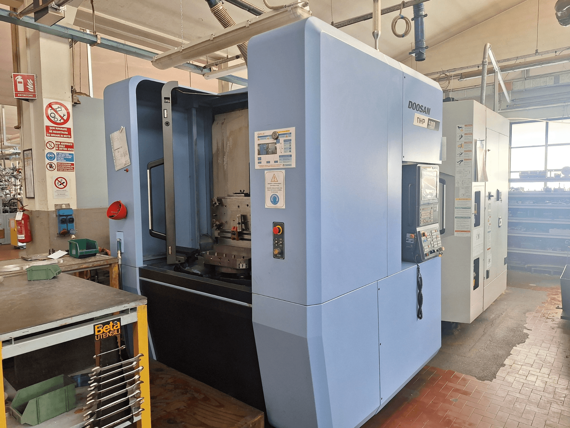 DOOSAN NHP 5000 horisontaalne töötlemiskeskus töökojas, külgvaates on näha selle juhtpaneel ja töötlemisala.