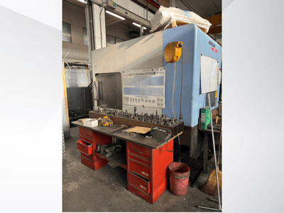 Doosan töötluskeskus punase töölaua ja ladustamise, tööriistade ja seadmete väljapanekuga, vaadatuna eestpoolt.