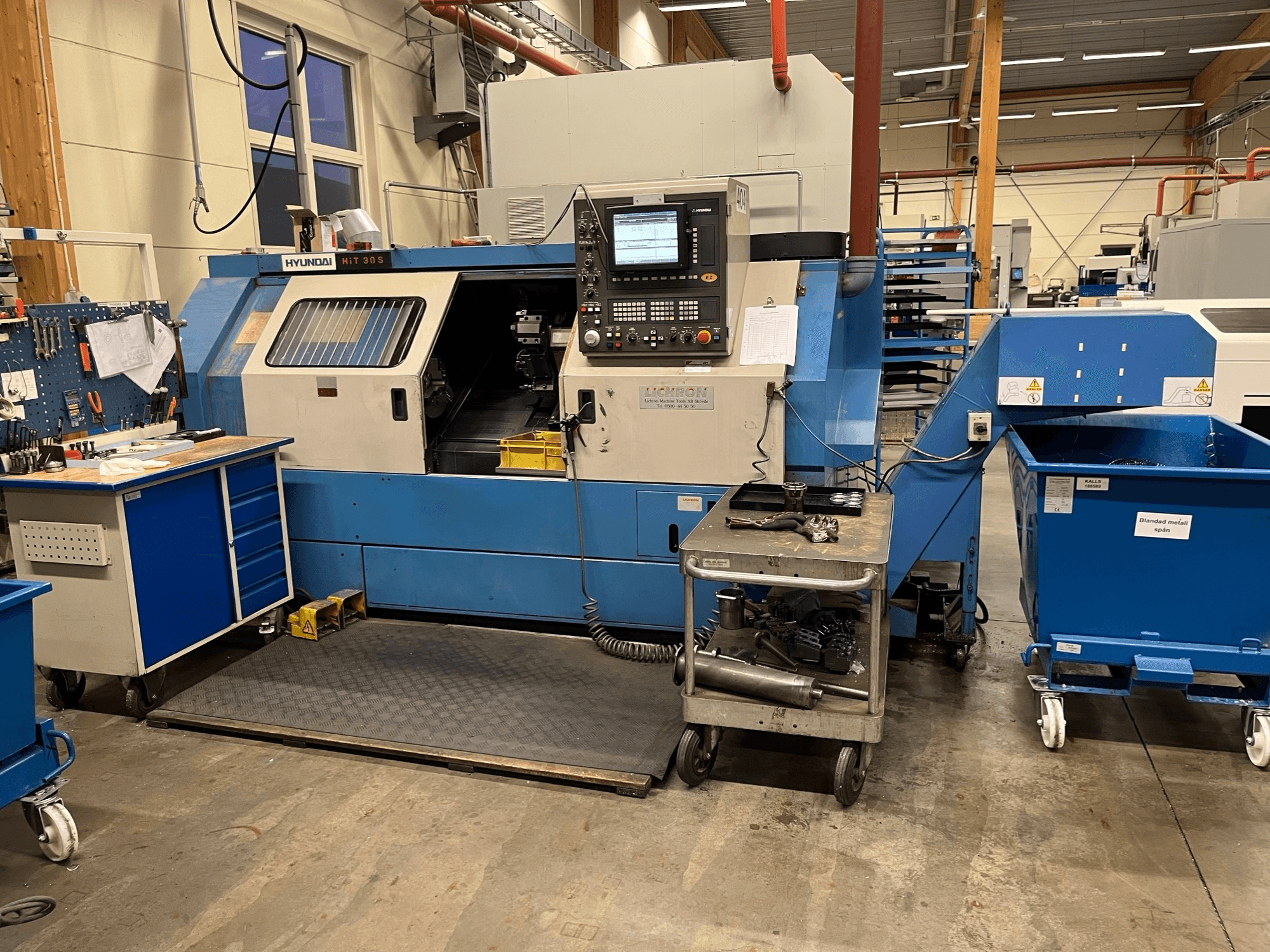 Hyundai HIT 30S horisontaalne treipingi, esivaade, juhtpaneel ja tööriistad lähedalasuval vankril töökojas.