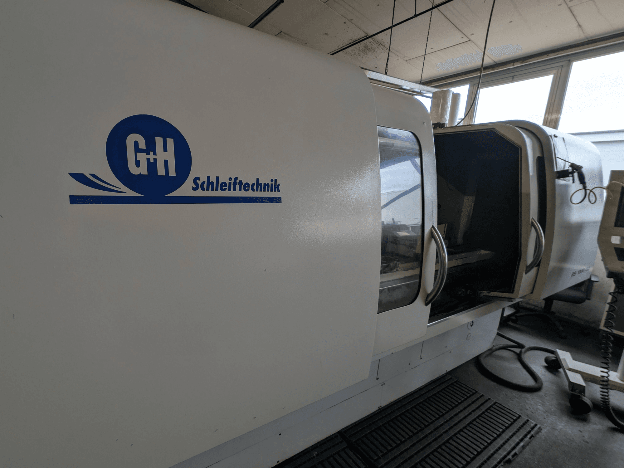 Silindriline lihvimismasin GEIBEL & HOTZ RS 1000 CU, külgvaade, kus on näidatud juhtpaneel ja avatud juurdepääsutuba.