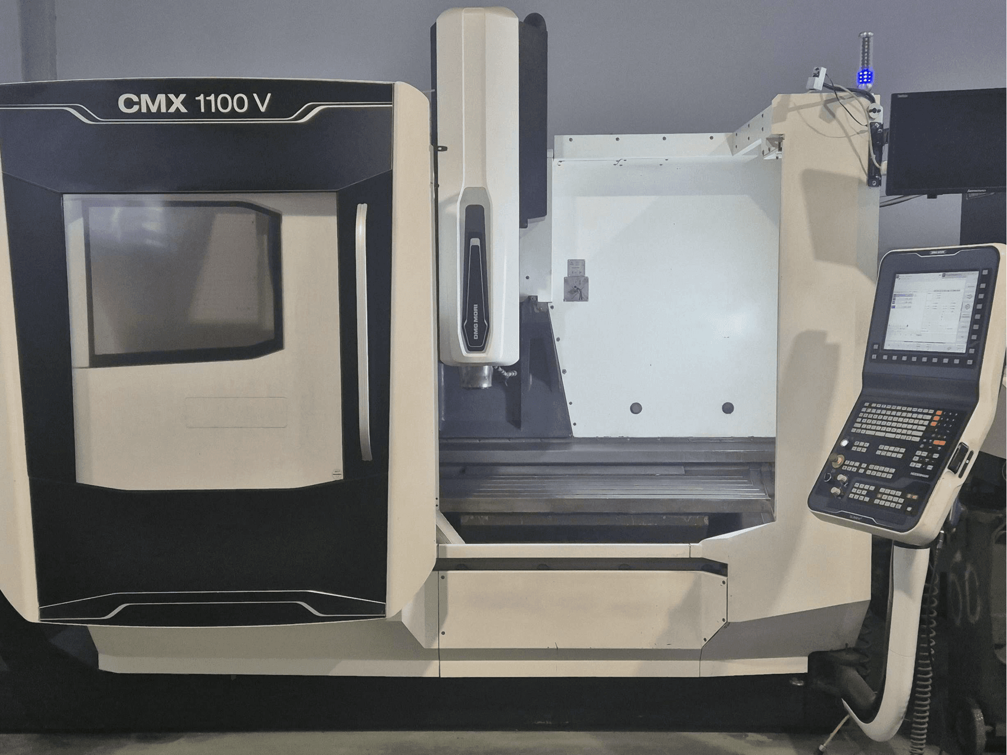 DMG MORI CMX 1100 V vertikaalne töötlemiskeskus, esivaade, millel on näha juhtpaneel ja masina alus.