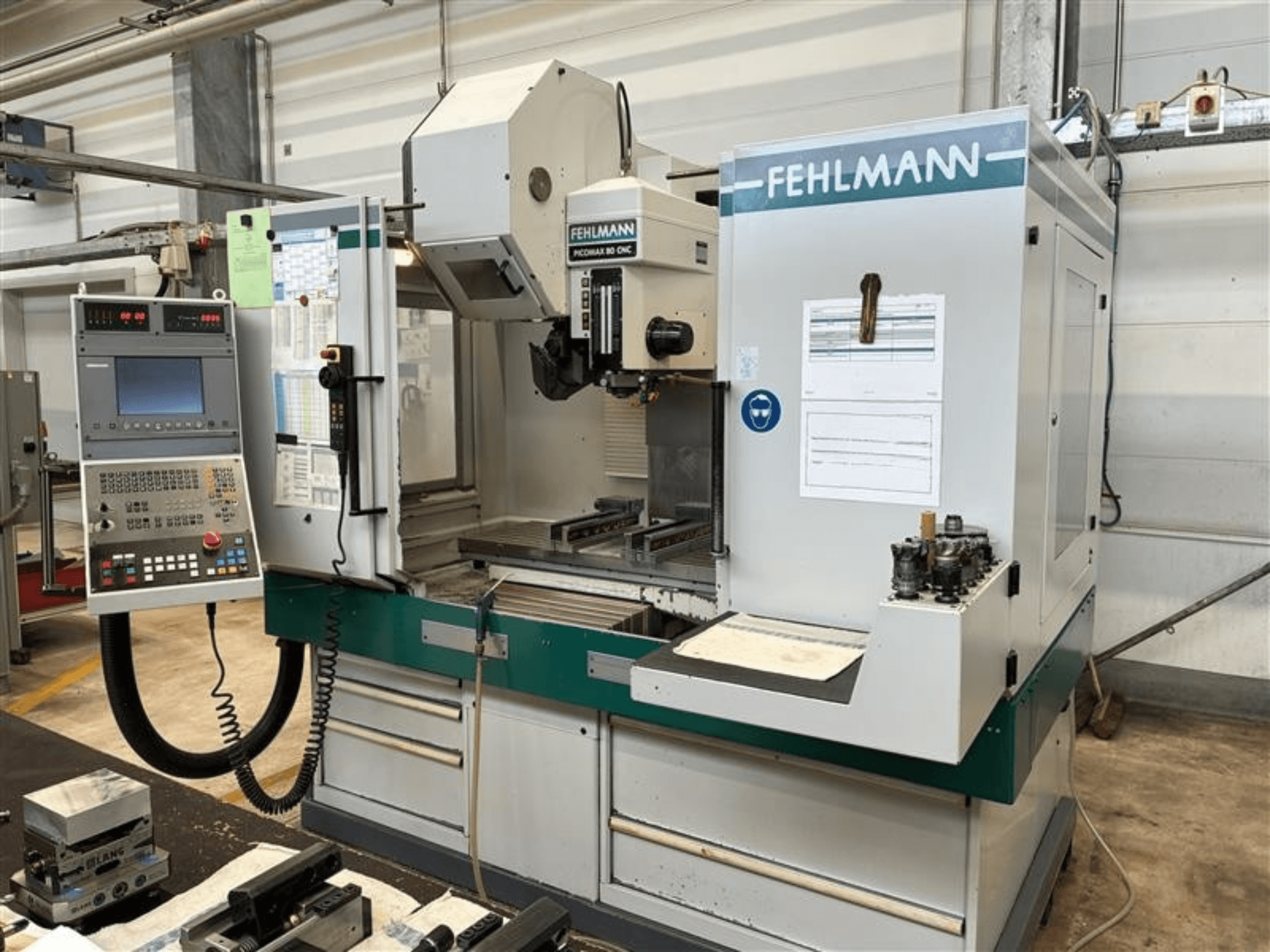 FEHLMANN PICOMAX 80 CNC-W 2/3 vertikaalne töötlemiskeskus, vaade eest, millel on näha juhtpaneel ja töötlemisala.