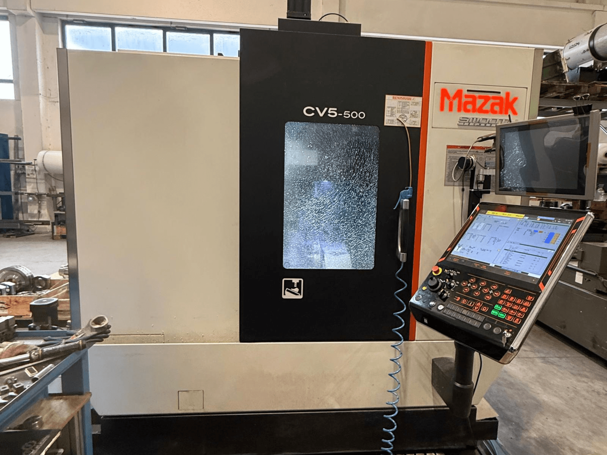 Mazak CV5-500 vertikaalne töötluskeskus, esikülg koos juhtpaneeli ja kuvariga, mis näitab tööseadistusi ja kasutajaliidest.