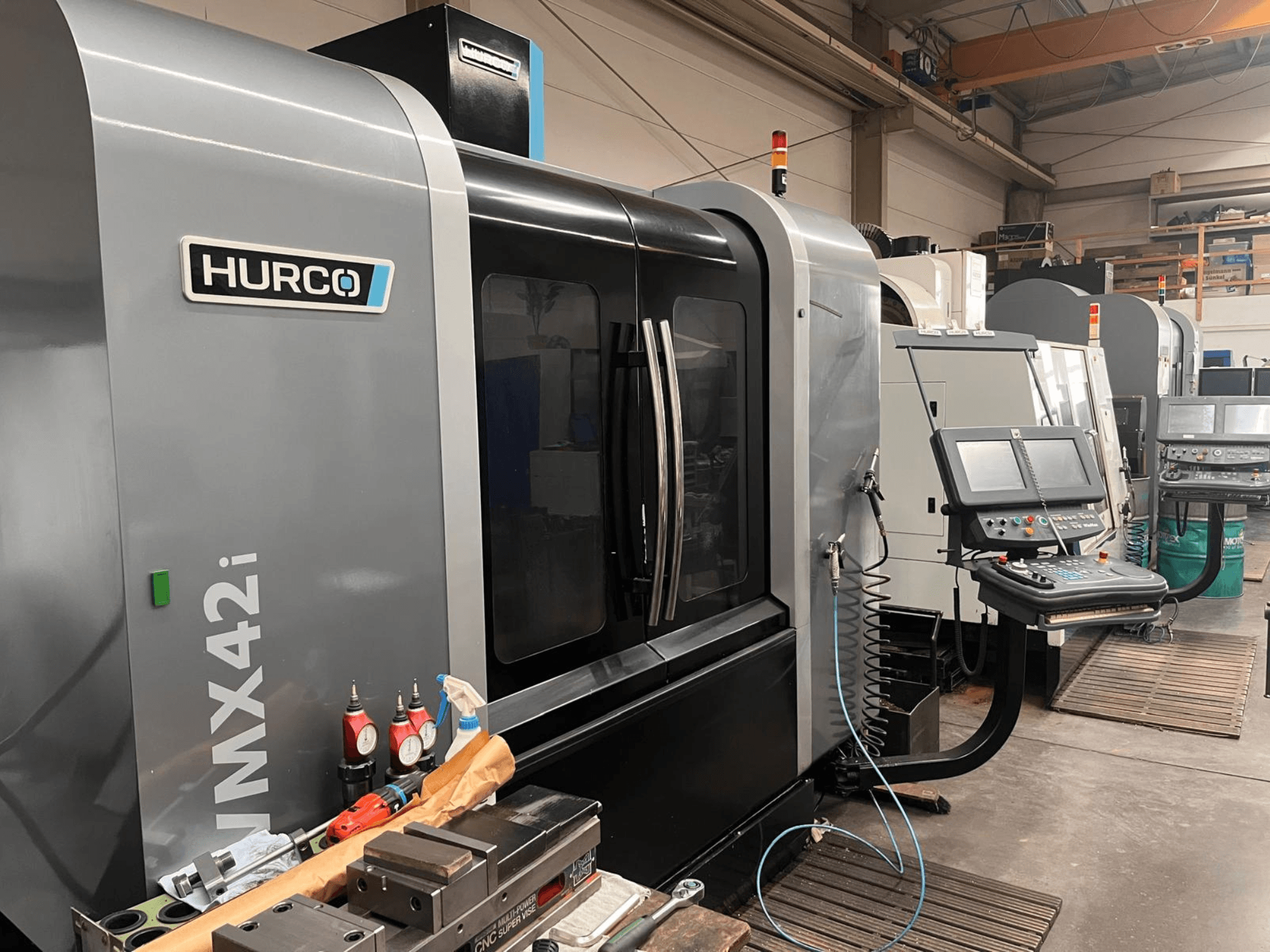 Hurco VMX42i CNC-tööpink töökojas, esivaade, kus on juhtpaneel ja erinevad tööriistad tööpinkidel.