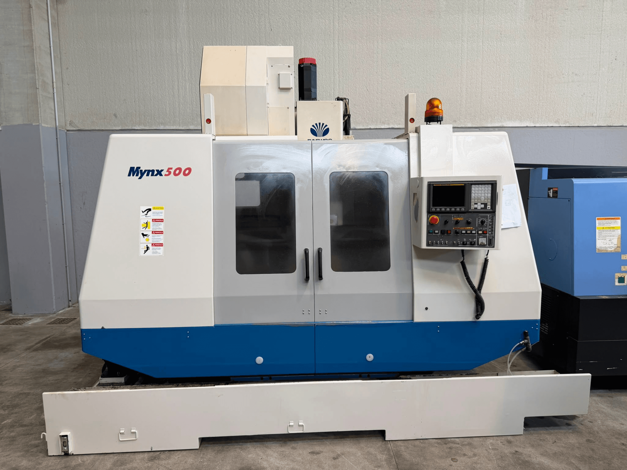 DAEWOO MYNX 500 vertikaalne töötlemiskeskus eestvaates koos juhtpaneeli, ohutusvalgustite ja läbipaistvate juurdepääsuluukidega.