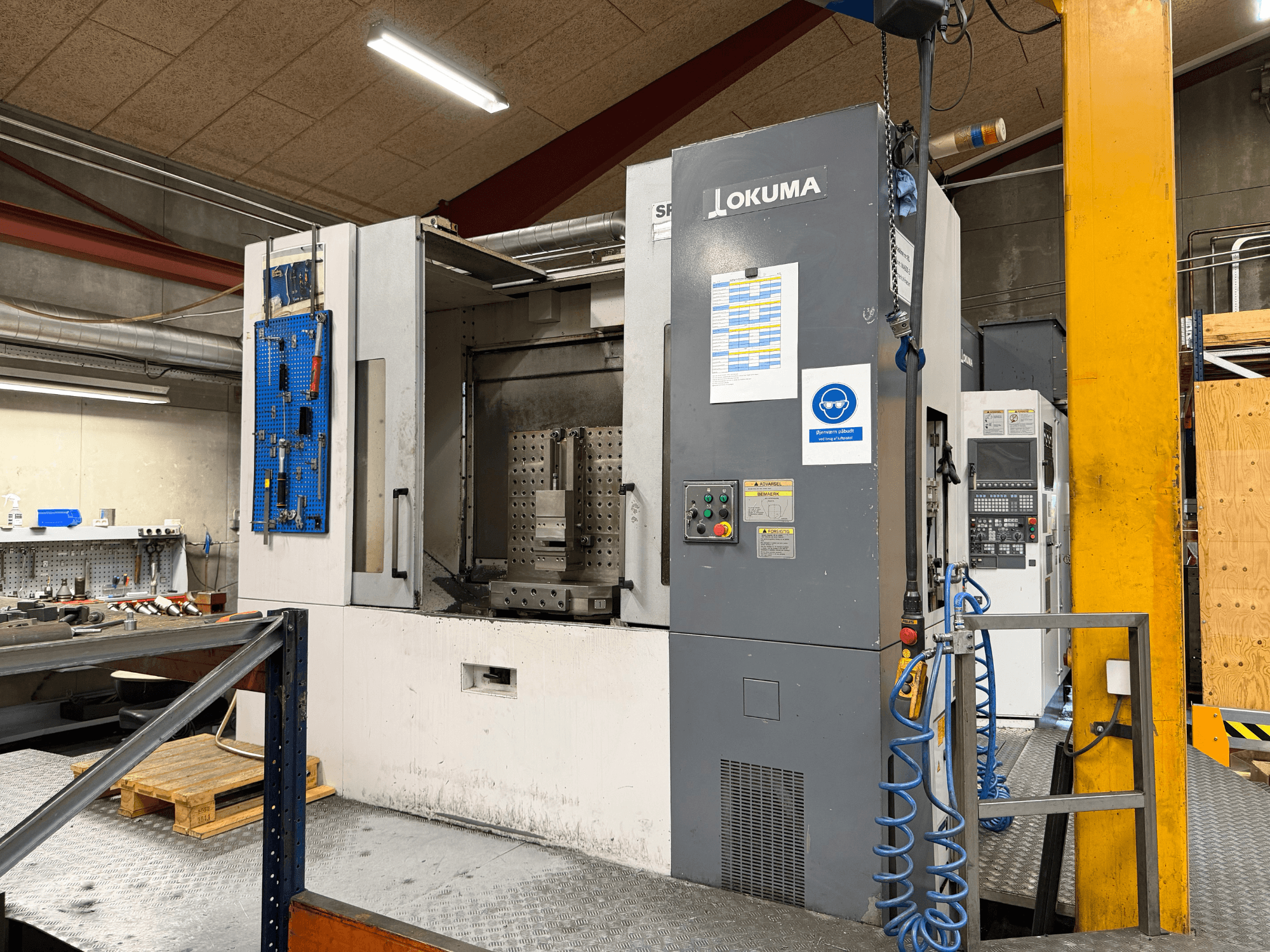 Okuma MA-600HB horisontaalne töötlemiskeskus töökodas, vaade eest, millel on näha juhtpaneel ja töötsoon.