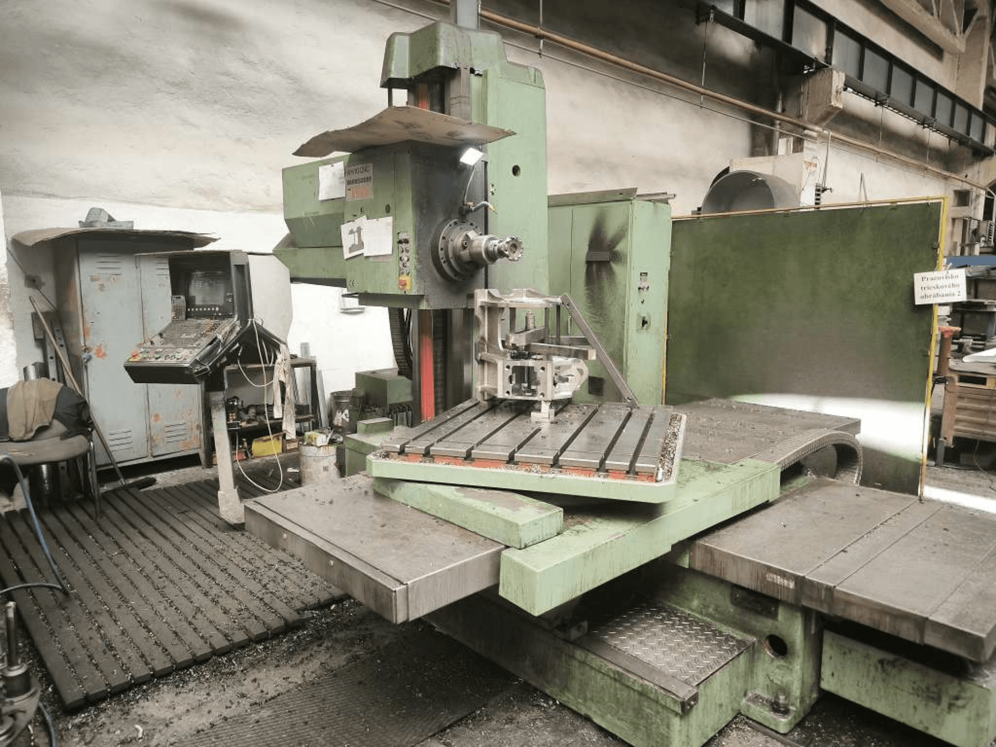 TOS WH 10 CNC-puurmasin vaadatuna eestpoolt, millel on näha töödeldud detail laual ja juhtpaneel.