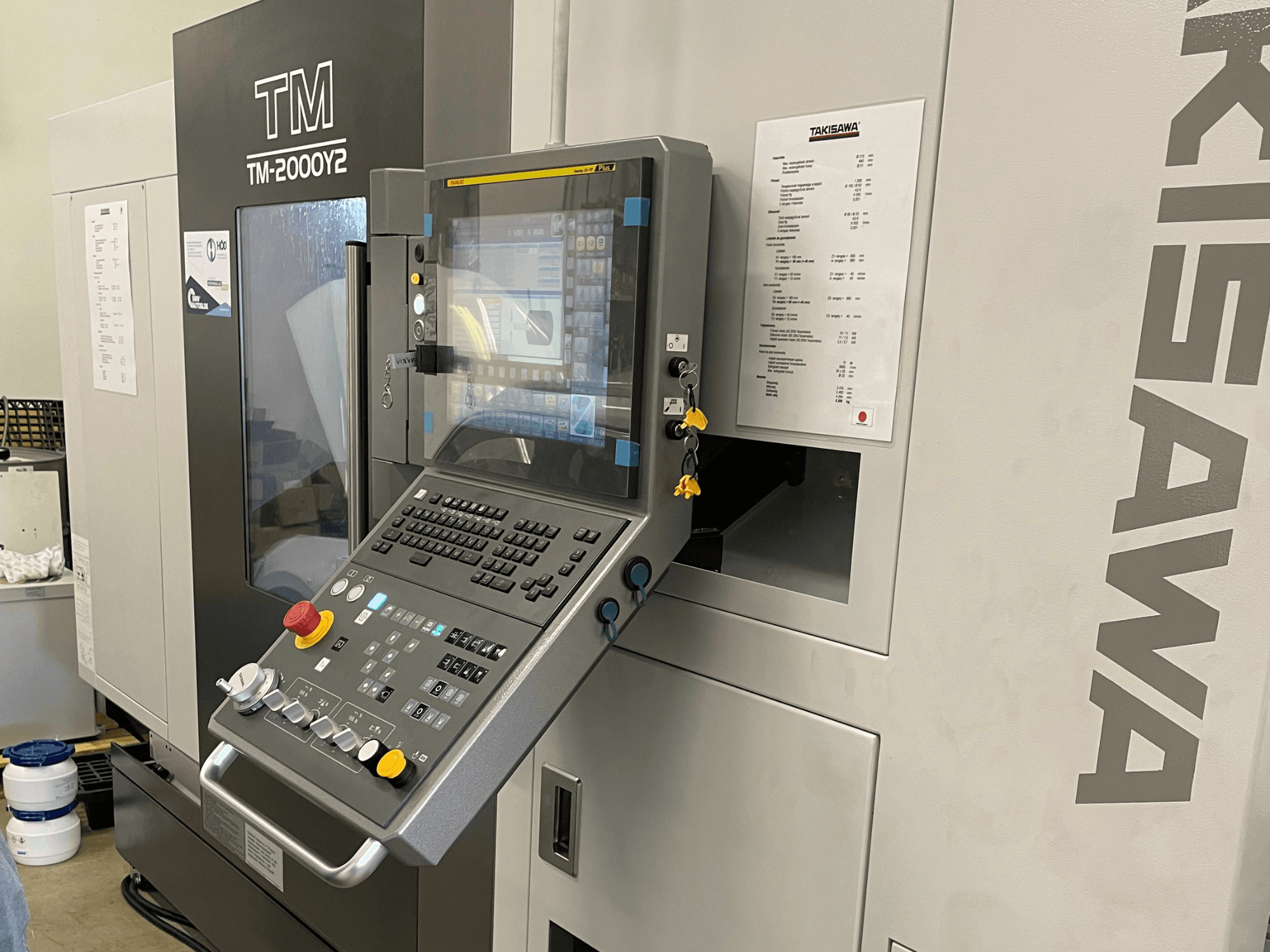 Takisawa TM-2000Y2 horisontaalse treipingi juhtpaneel esiplaanil, millel on digitaalne ekraan ja kasutamisnupud.