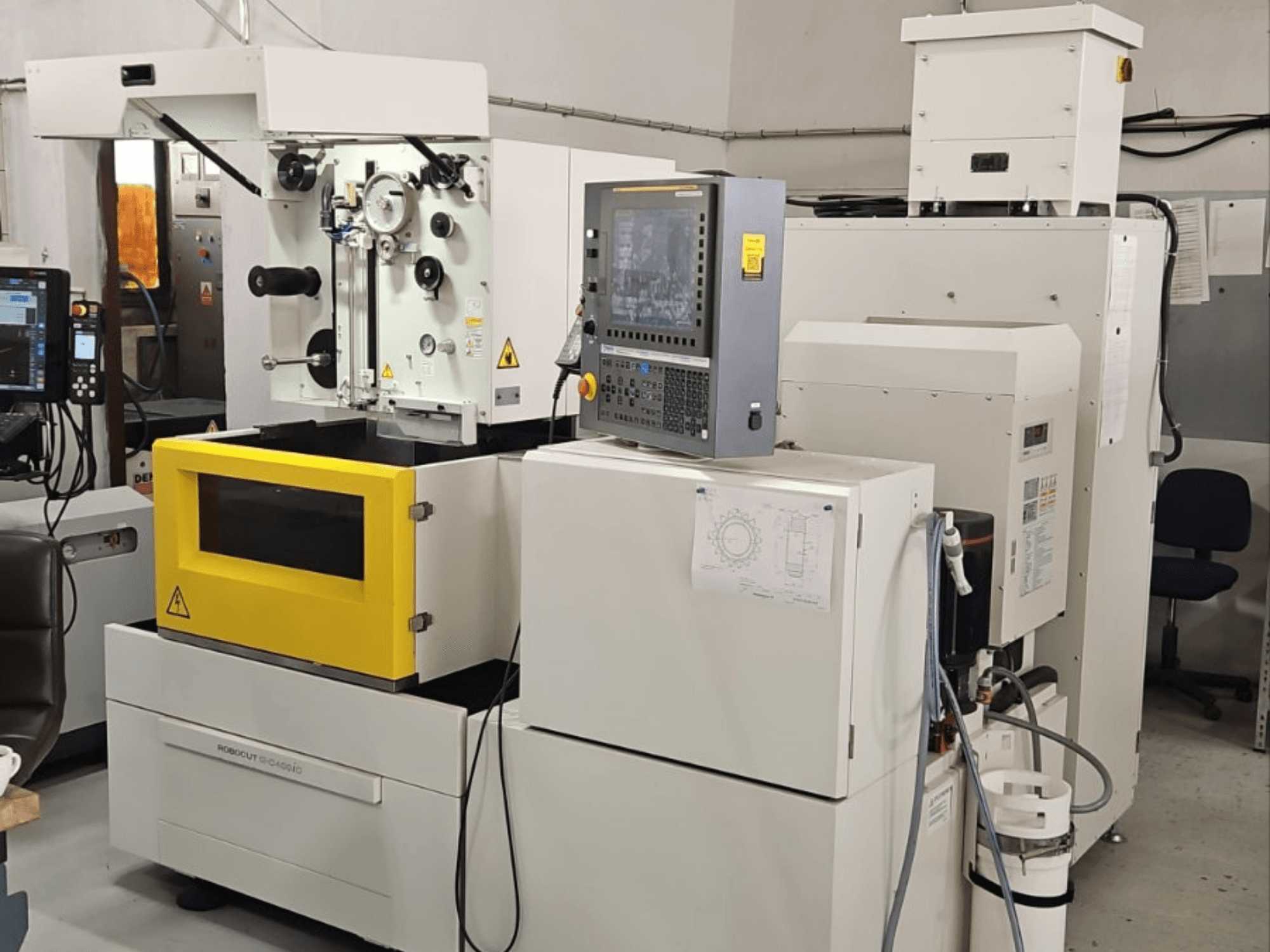 FANUC Robocut alpha C400iC traat-EDM-masin, esivaade, millel on näha juhtpaneel ja kollane töökamber.