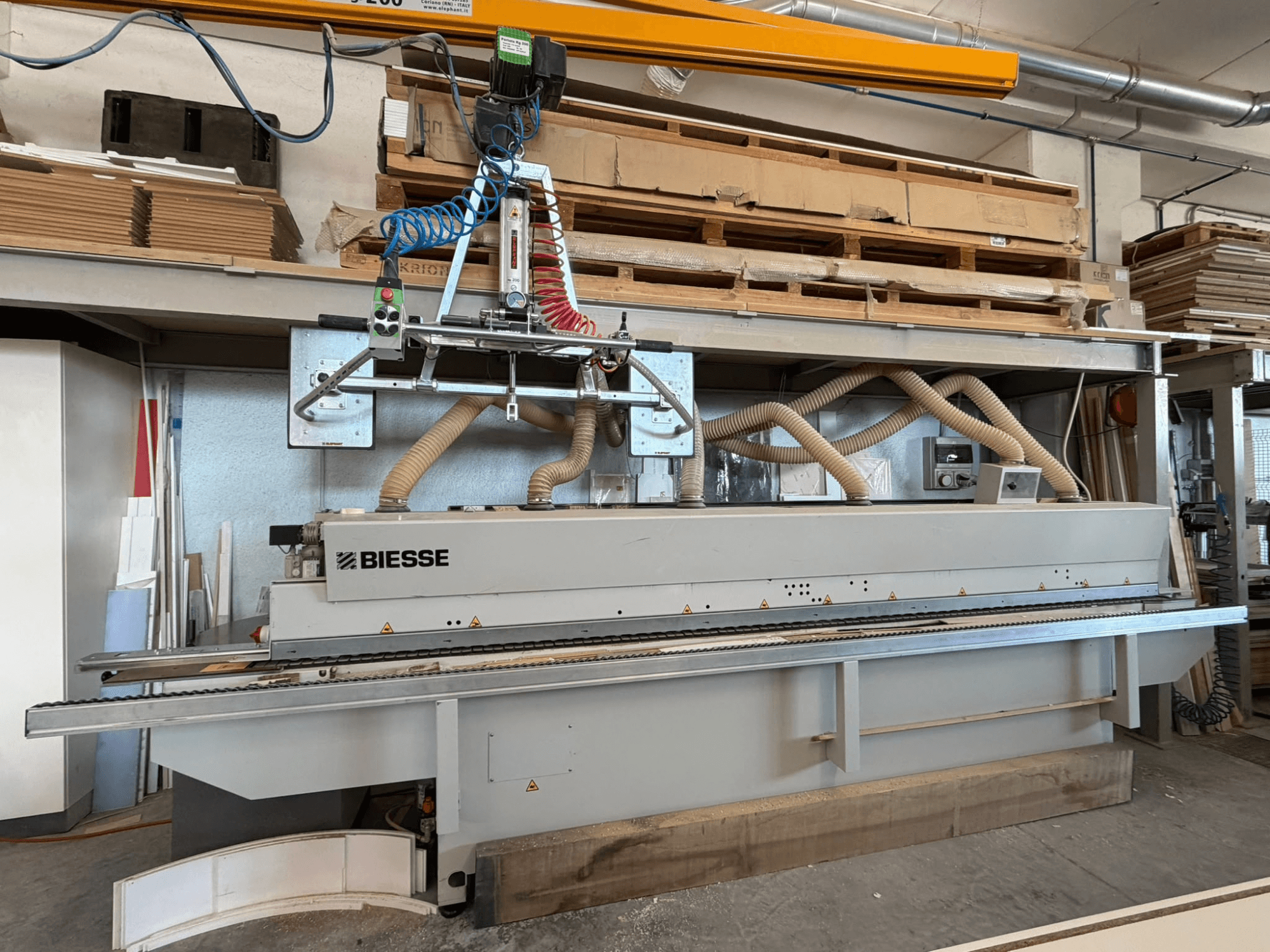 Töökojas asuv BIESSE AKRON 1330 servakleebimismasin, millel on näha esivaade koos juhtpaneeli ja tolmuimejaga.