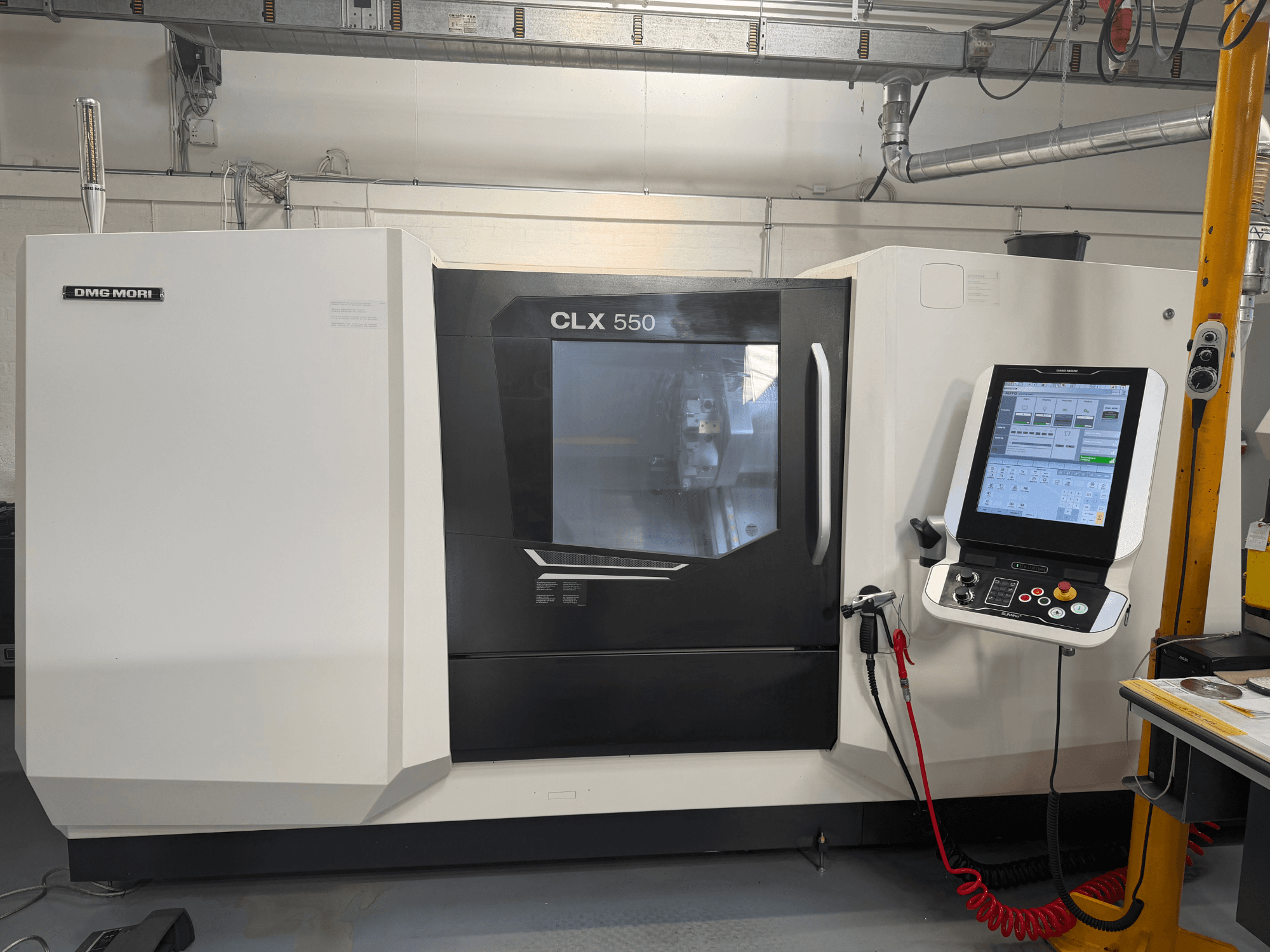 DMG MORI CLX 550 V4 horisontaalne treipink, vaade eest koos juhtpaneeli ja ekraaniga, mis tutvustab täiustatud töötlemisfunktsioone.