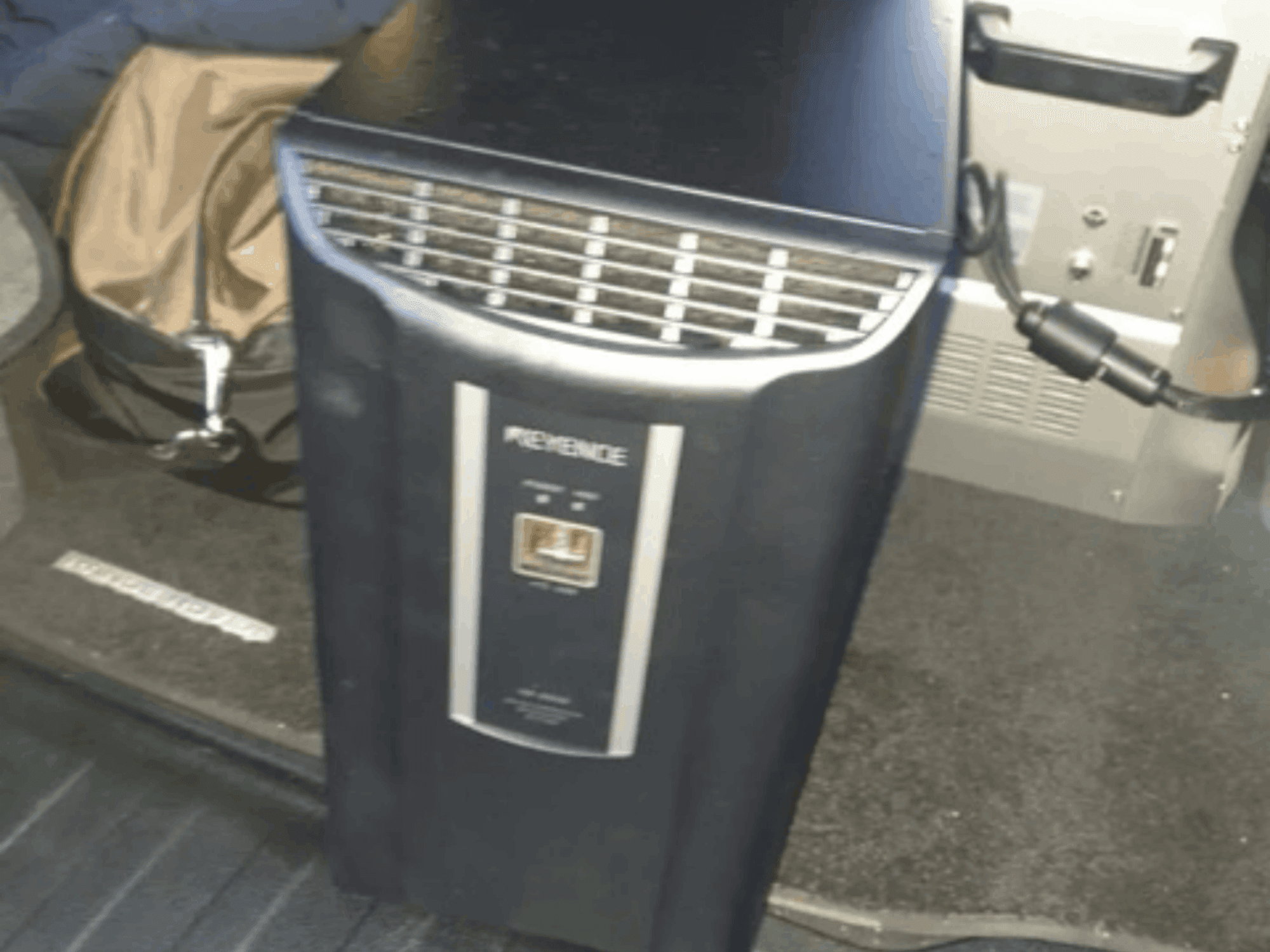 KEYENCE IM-8030 automaatikasüsteem esiplaanil, kus on näha juhtpaneel ja ventilatsiooniavad sõiduki siseruumi taustal.