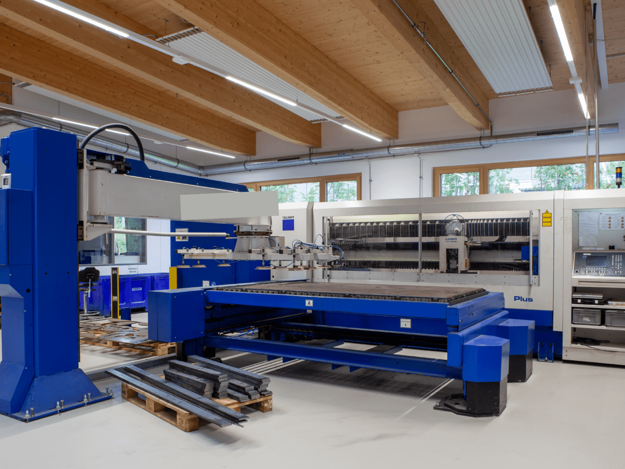 TRUMPF TRUMATIC L 2530 Plus CO₂-laserlõikepink töökodas, millel on suur lõikepind ja tööstuslik disain.