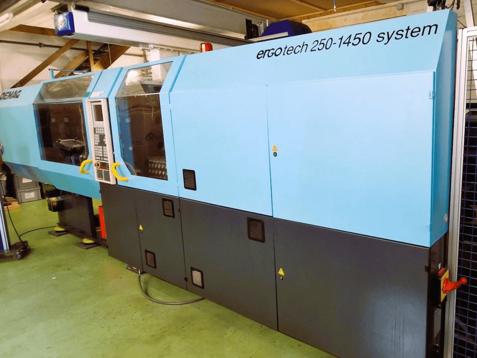 Ergotech 250-1450 süsteemne survevalu masin, esiplaanil, sinine ja must värv, juhtpaneel ja turvaelemendid nähtavad.