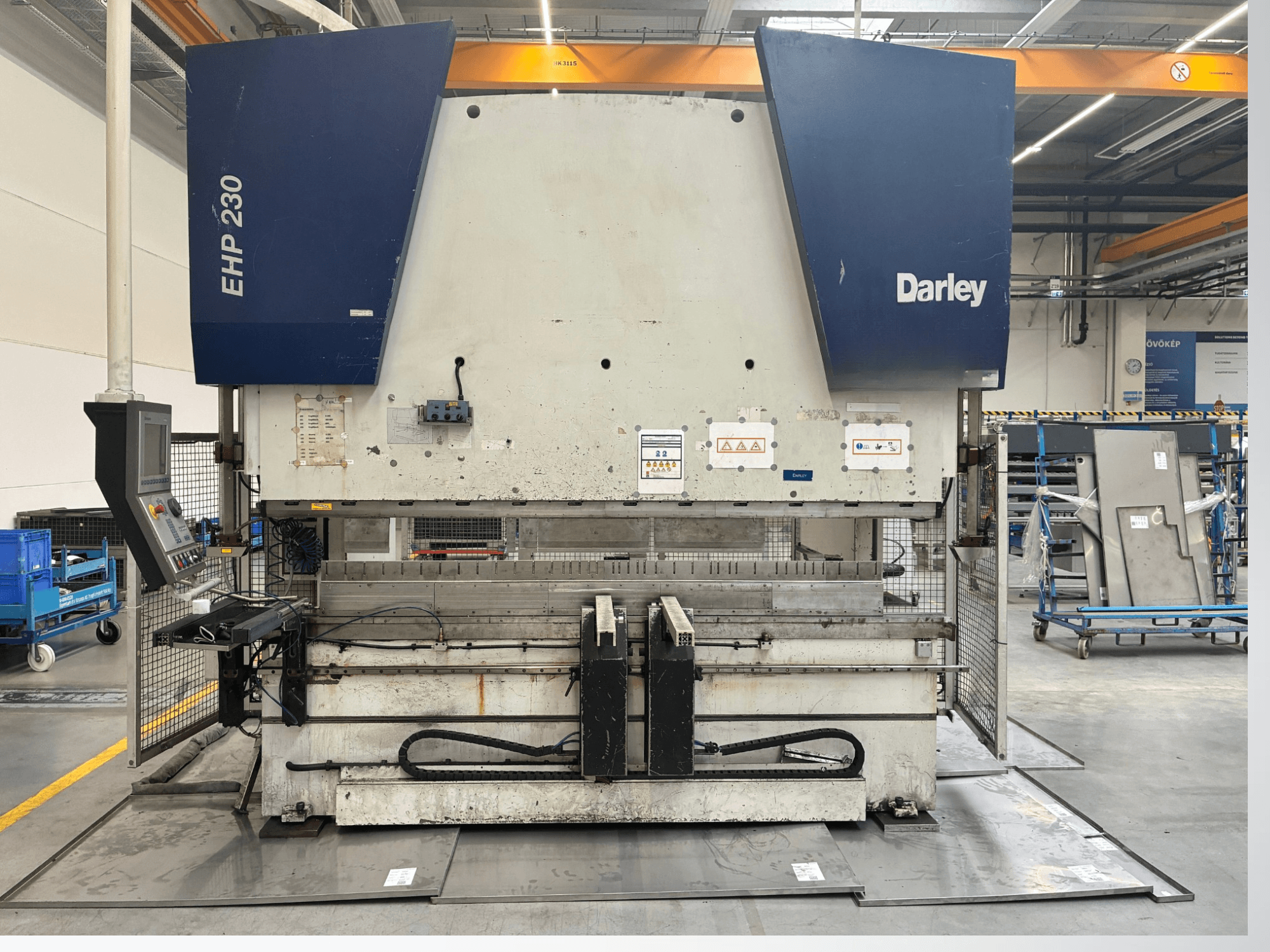 Hüdrauliline press Darley EHP-LS 230.31/25, esiplaanil, juhtpaneel ja metallplaadid lähedal. Ideaalne tööstuslike rakenduste jaoks.
