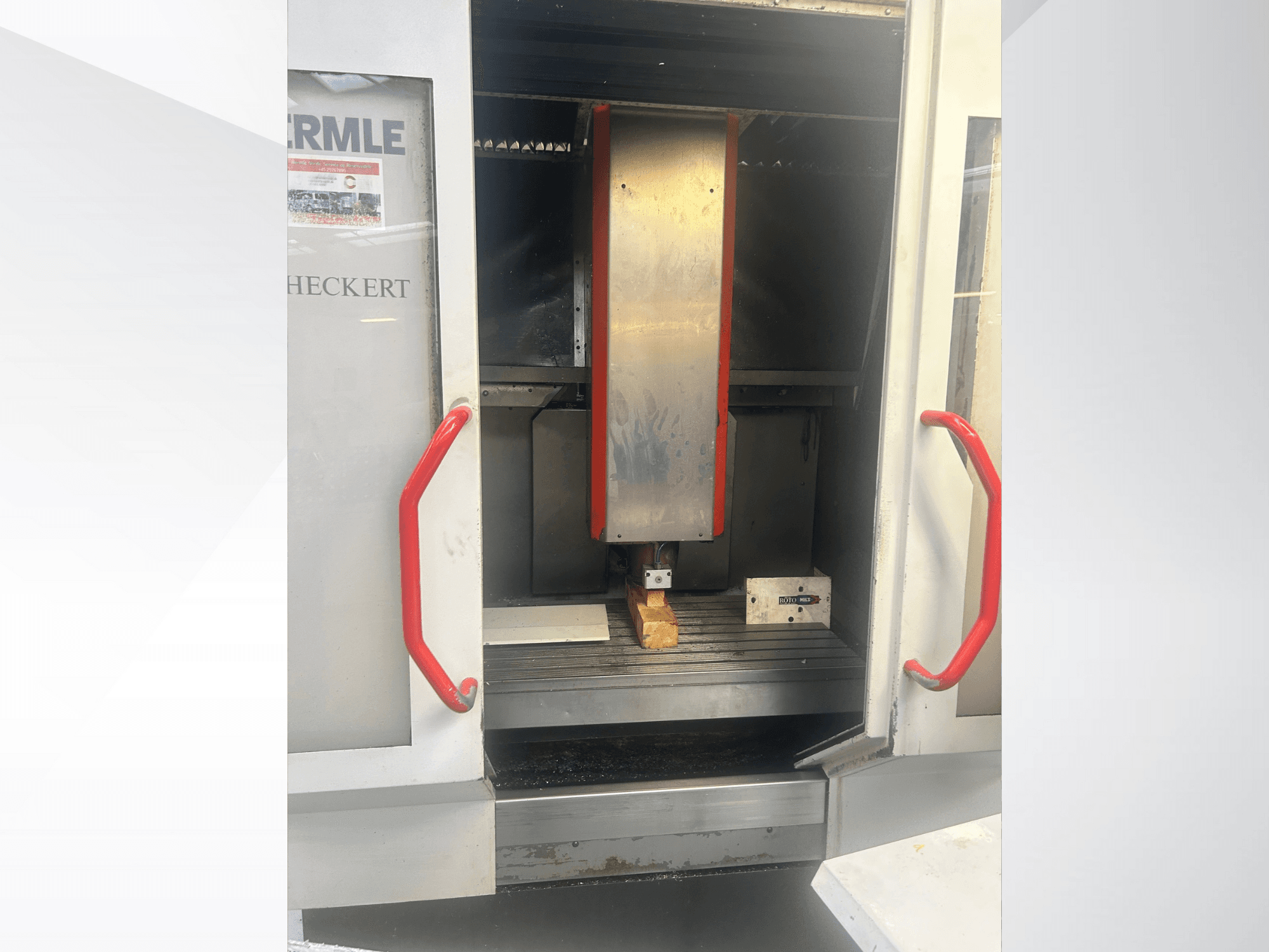 Hermle CNC-pingi esivaade, millel on metallist sisemus, punased käepidemed ja töölaual olev detail.