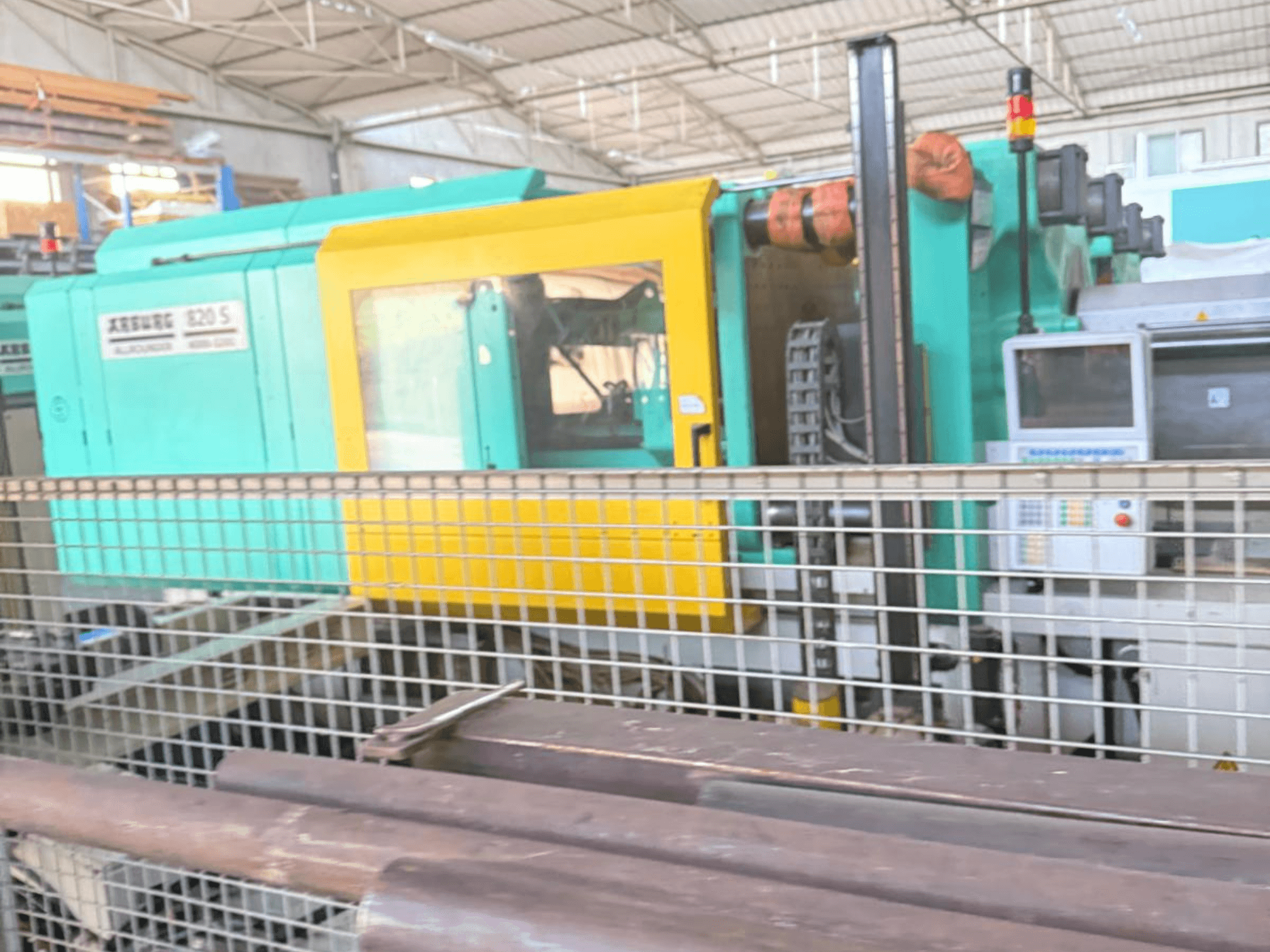 Hüdrauliline survevalu masin Arburg SELECTA 820 S 4000-3200, külgvaade, kus on näha juhtpaneel ja värviline kollane ja sinimustvalge kujundus.