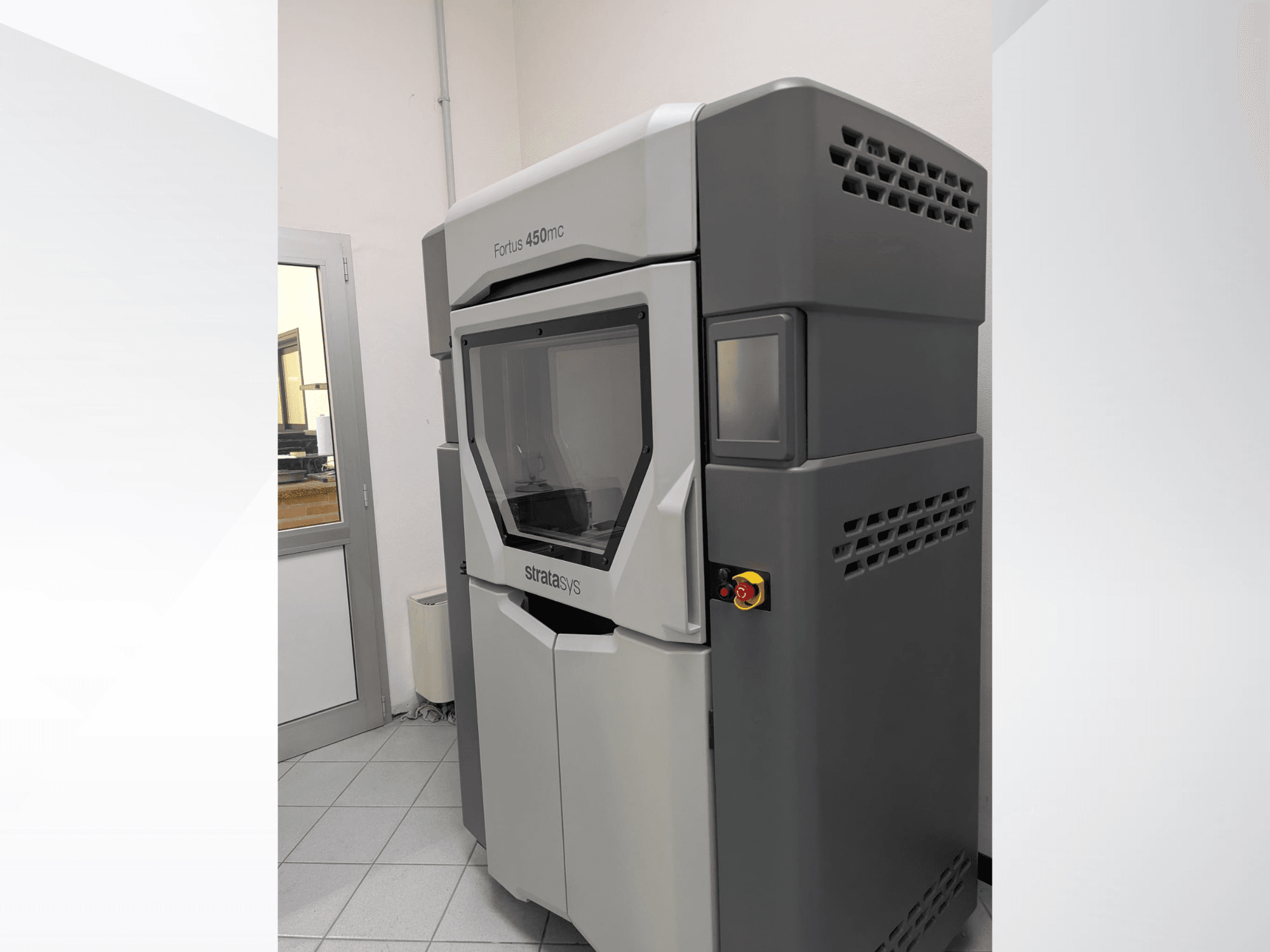 Stratasys FORTUS 450mc plastikust 3D-printer külgvaates, millel on stiilne disain ja juhtpaneel.