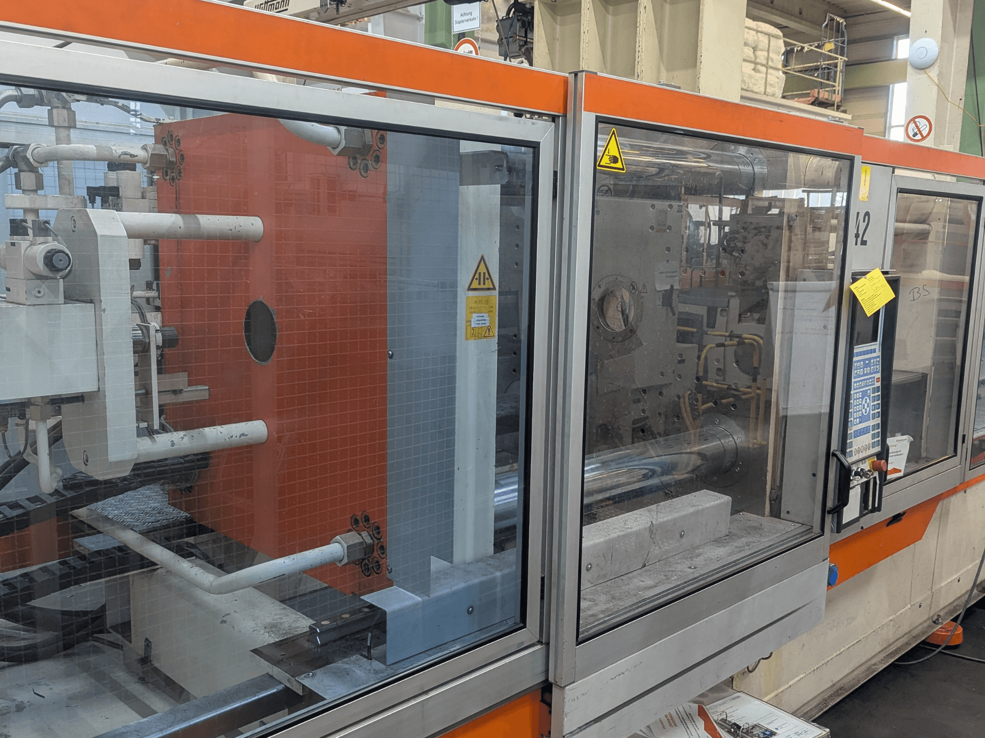 DEMAG SYSTEC 80/420-310 hüdraulilise survevalu masina esiplaanil, kus on näha juhtpaneel ja masinaosad.