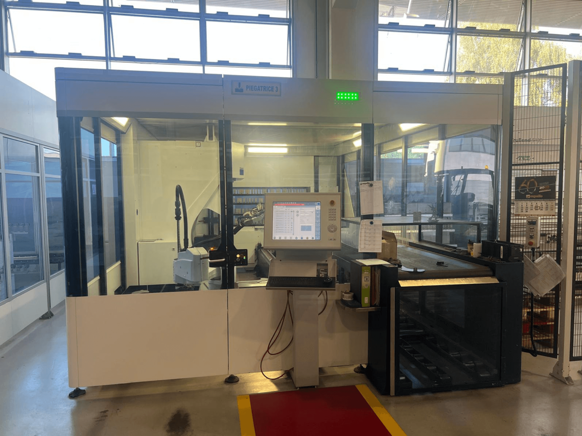 Tööstuslik painutusmasin, mudel Piegatrice 3, esivaade koos juhtpaneeli ja robotkäega, hästi valgustatud töökojas.