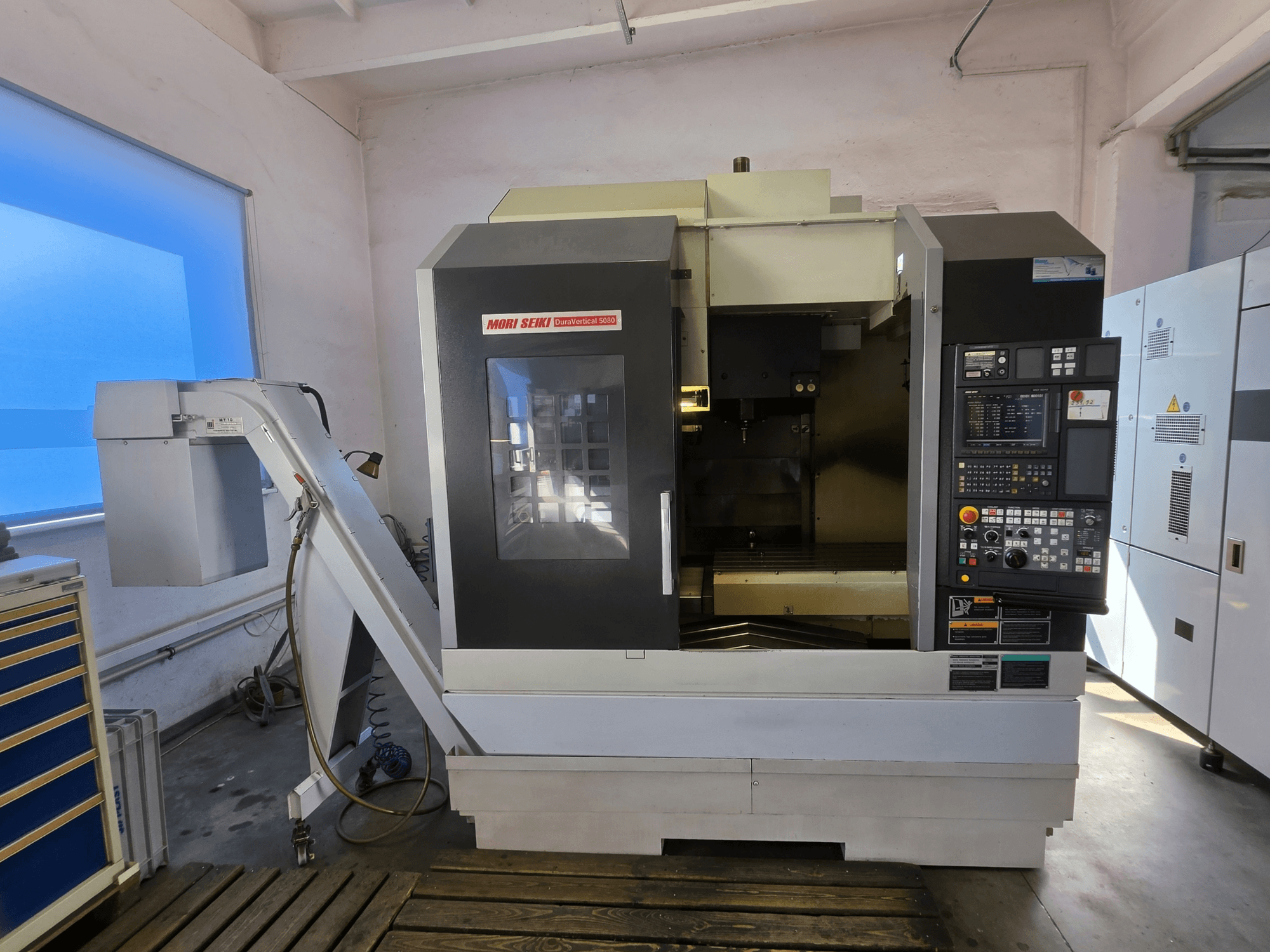 MORI SEIKI DuraVertical 5080 vertikaalne töötlemiskeskus, esivaade, millel on näha juhtpaneel, spindel ja tööriistahoidja.