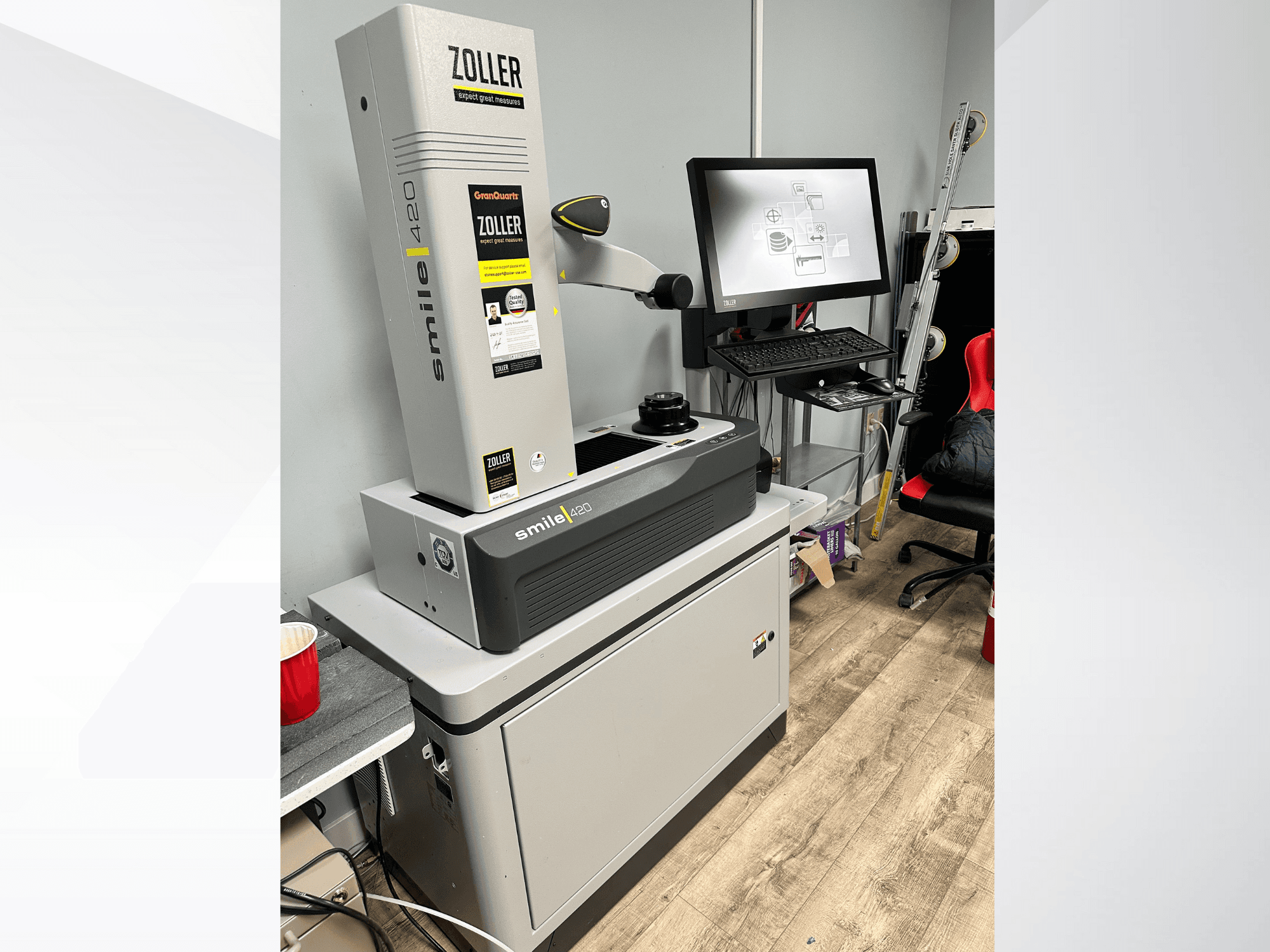 Zoller Smile 420, digitaalne mõõtmismasin, esiplaanil koos monitori ja tööruumiga taustal.