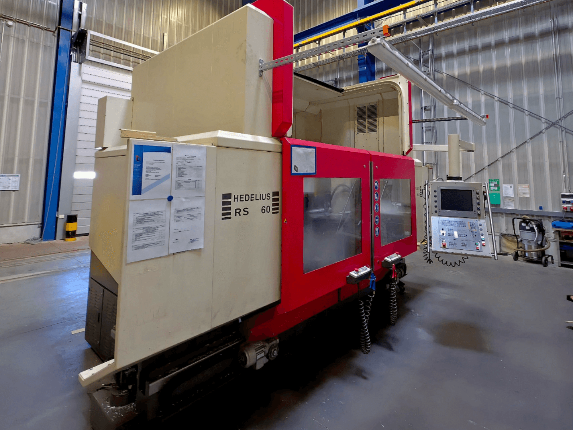 HEDELIUS RS 60 K - 2000 vertikaalne töötluskeskus, külgvaade, juhtpaneel ja ohutusjuhised nähtavad.