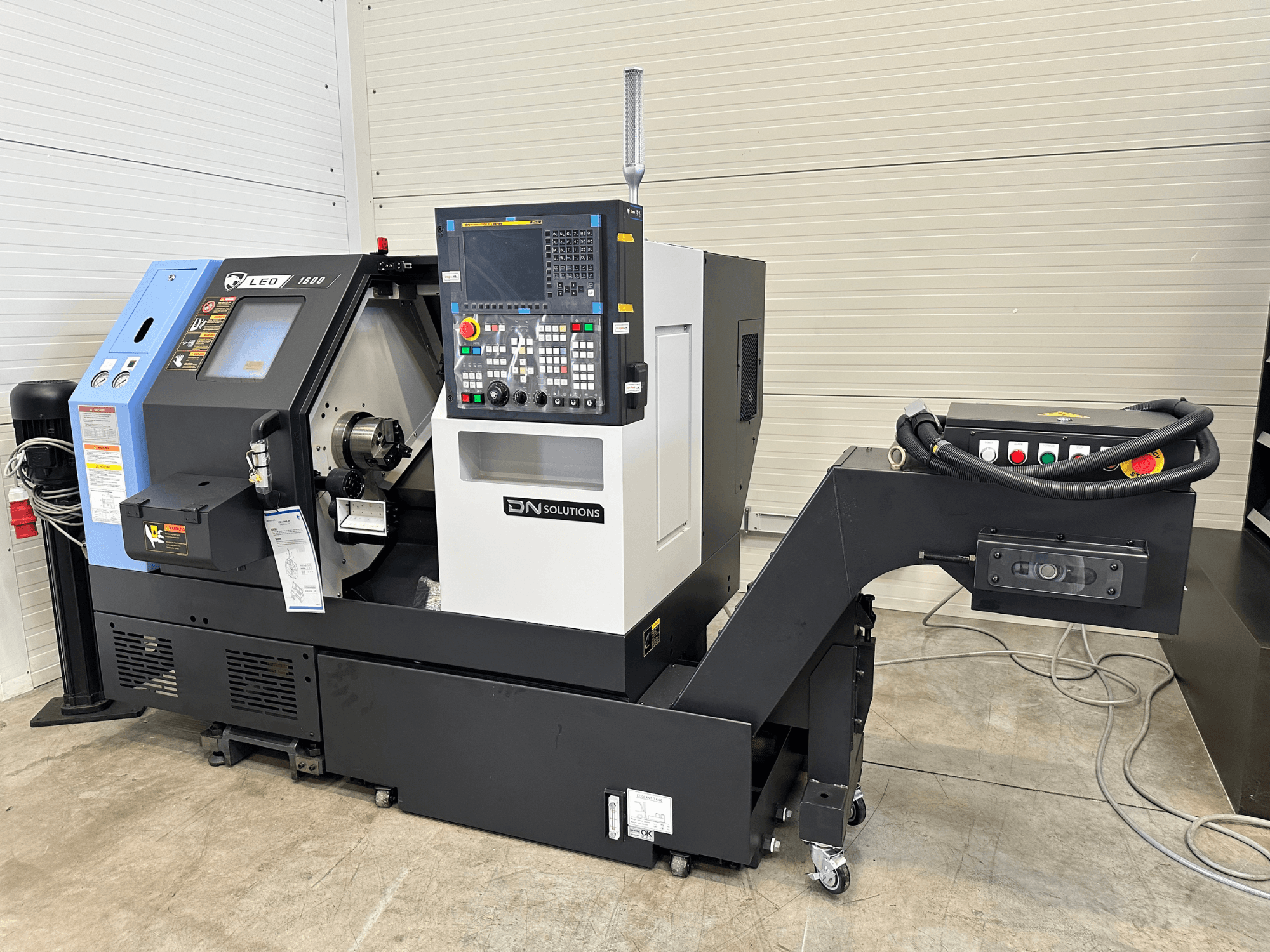 DN SOLUTIONS Leo 1600 treipingi keskuse esiplaan, millel on digitaalne juhtpaneel ja tööriistahoidik mustal alusel.