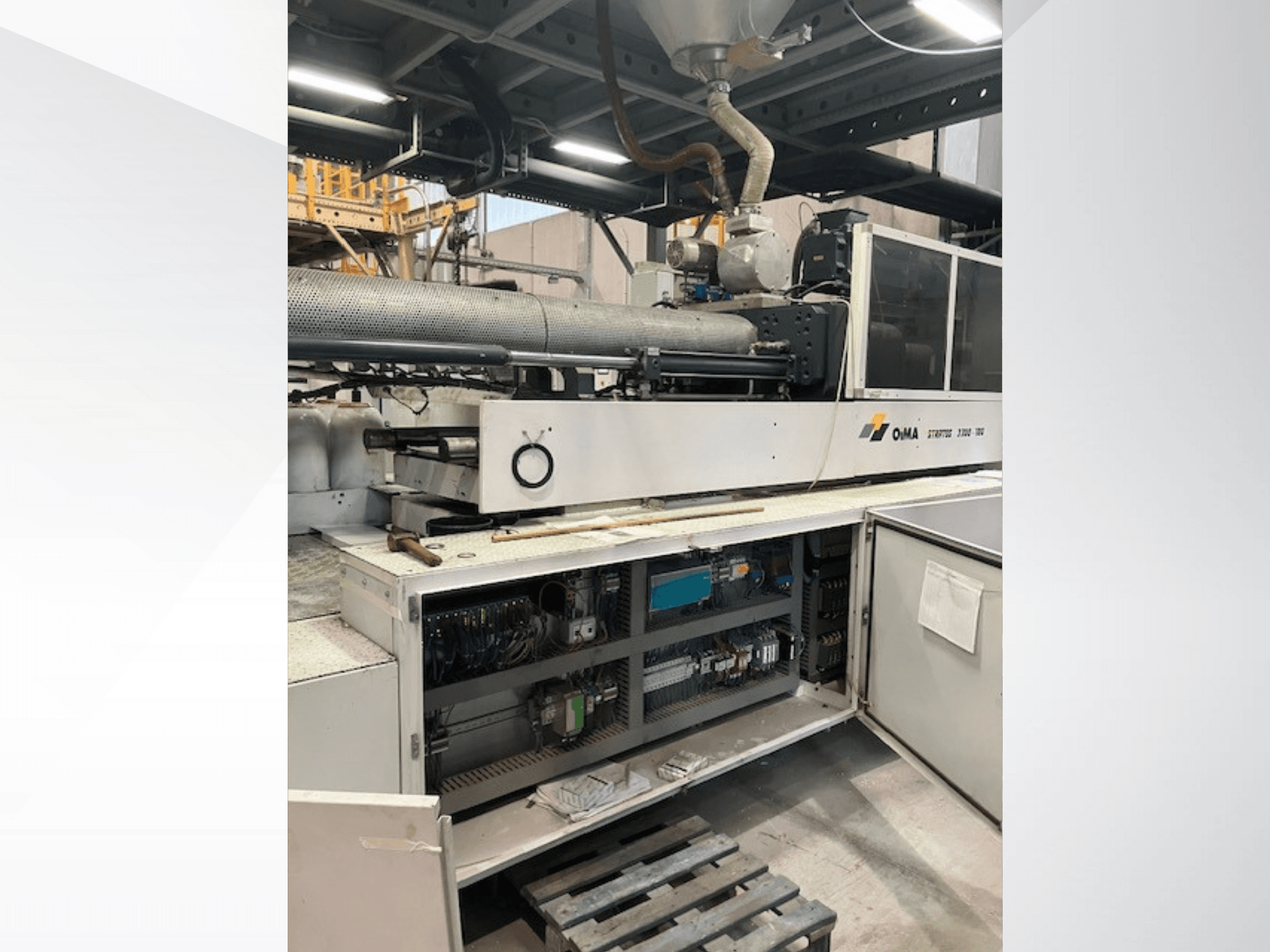 OMA Extruder 3500 esiosa, kus on näha töötavaid osi, juhtpaneel ja juhtmestiku üksikasjad. Rasked masinad tööstuslikus keskkonnas.