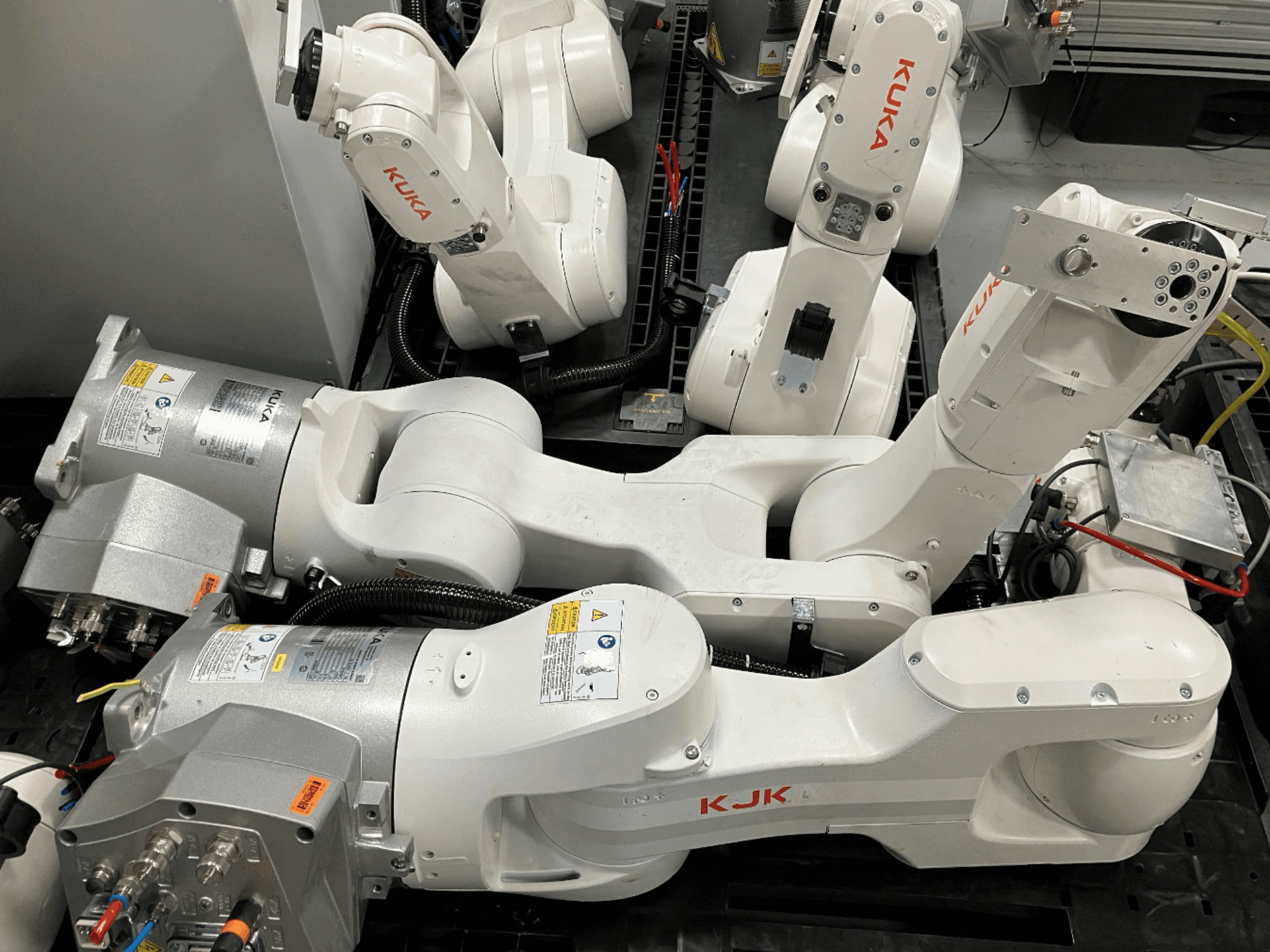 KUKA KR 10 R900 CR robotkäsi külgvaates, mis näitab liigendikonstruktsiooni, mootoreid ja juhtmestiku üksikasju.