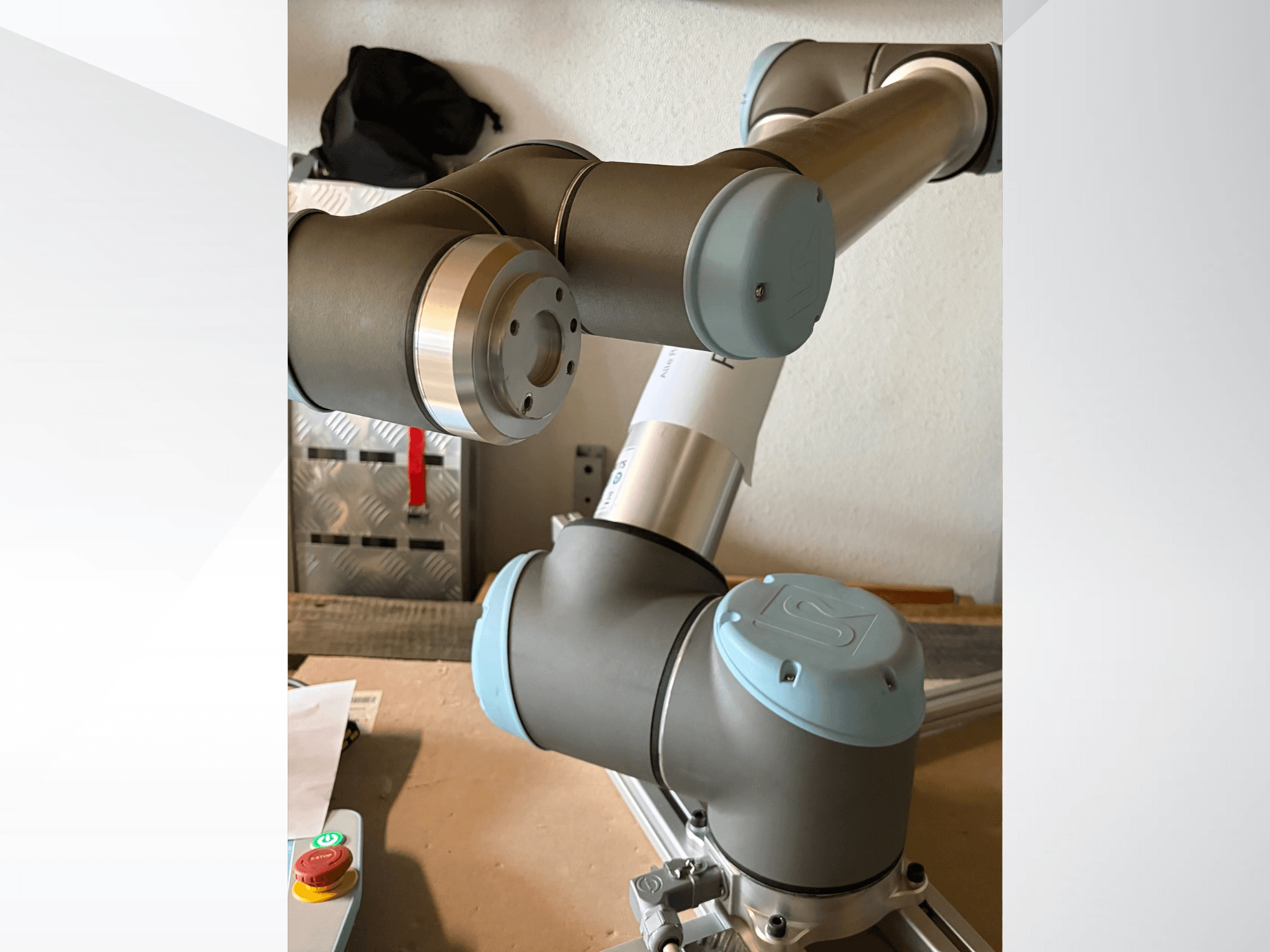 Universal Robots UR10 robotkäe külgvaade, kus on esile toodud liigendid ja hallikas-sinised disainielemendid.