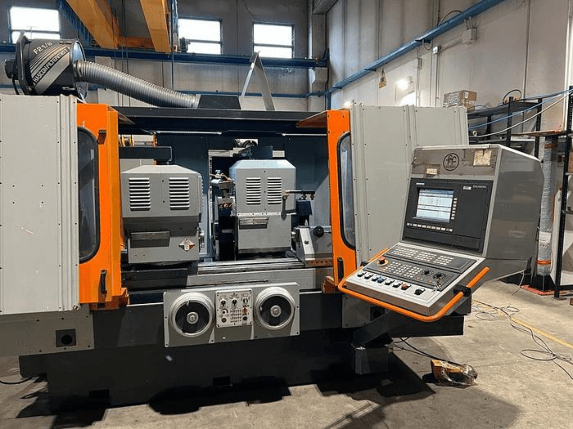 Kahe spindli, juhtpaneeli ja oranžide aktsentidega CNC-pingi esivaade. Omadused ventilatsioonikanal ja juhtimisseadmed.
