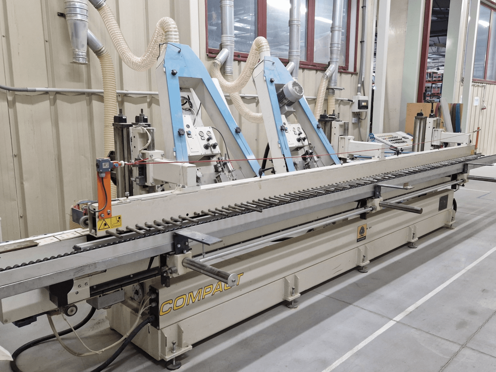 Lihvlihvataja TECNOLEGNO COMPACT 52 töökojas, kus on näidatud juhtpaneel ja lihvimisriba mehhanism külgvaates.