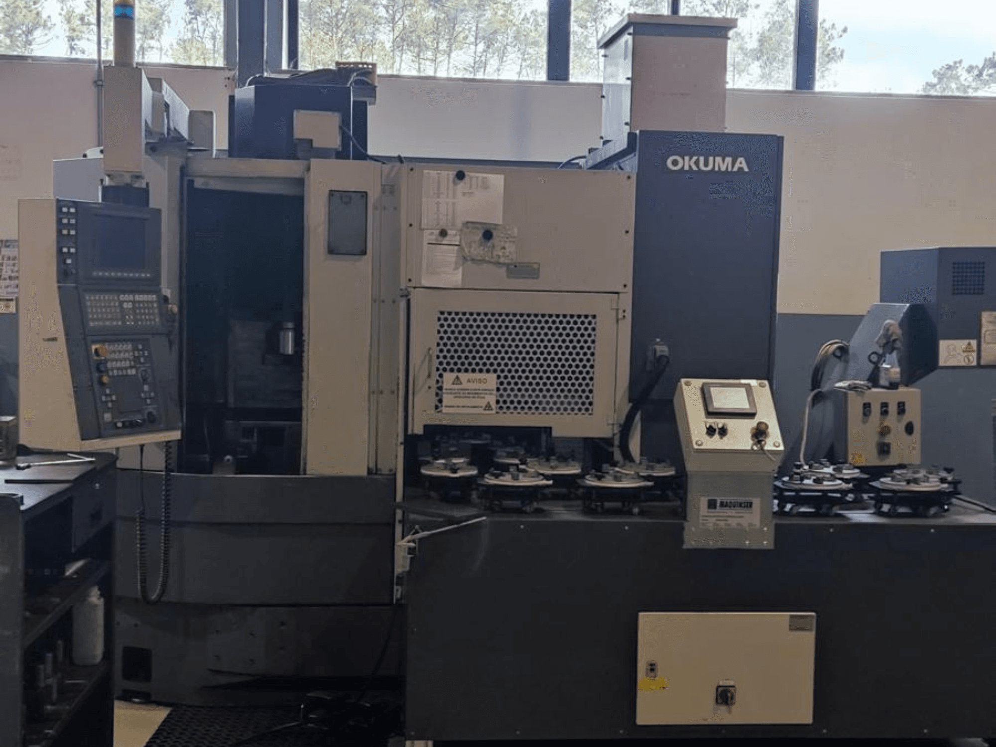 Okuma LVT300 vertikaalne treipink eesvaates, millel on juhtpaneel, tööriistahoidjad ja tööpind.