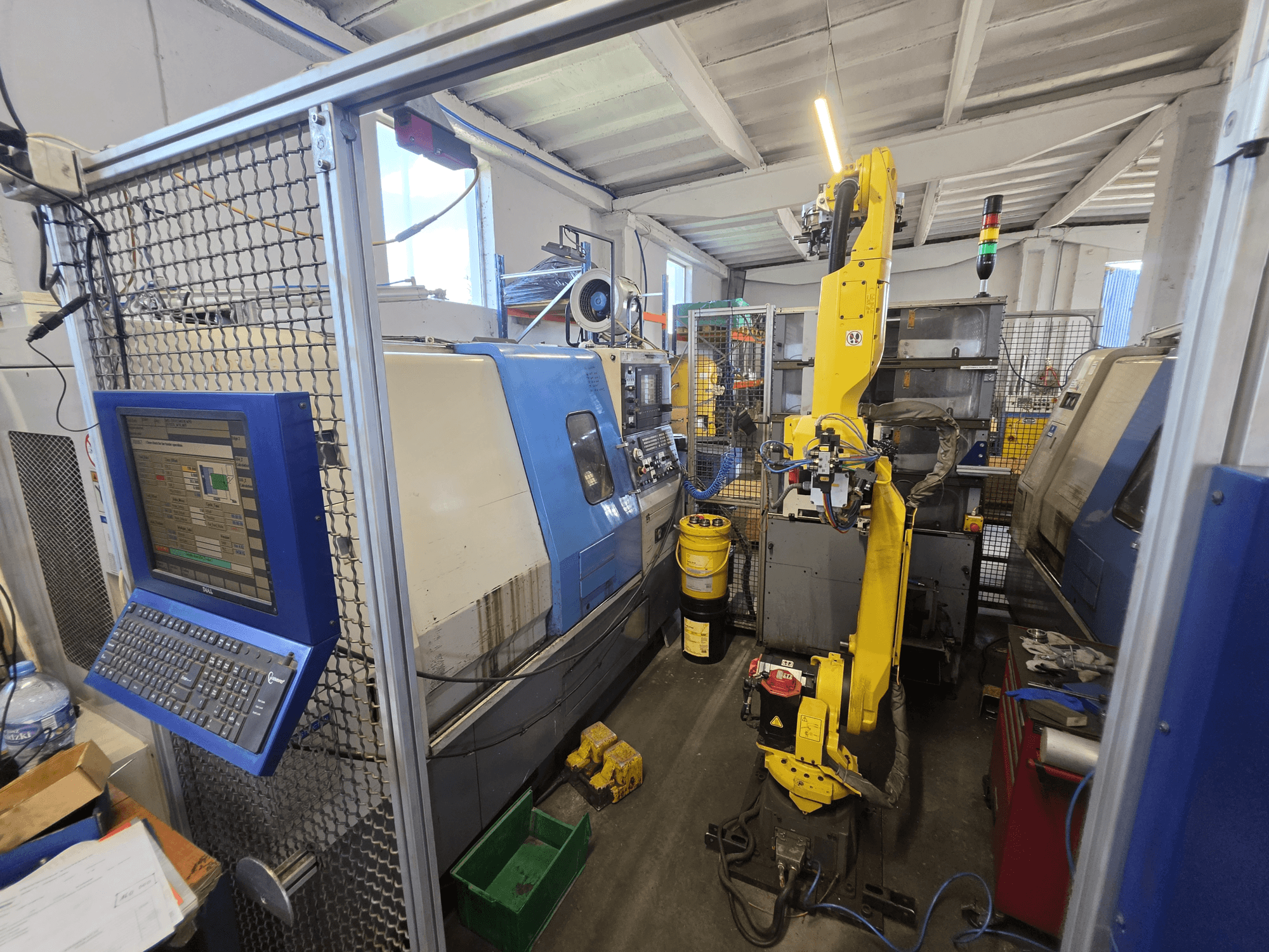 Hyundai HIT-200C horisontaalne treipink koos FANUC M-20iA robotiga, esivaade, millel on näha juhtimispaneel ja seadme paigutus.