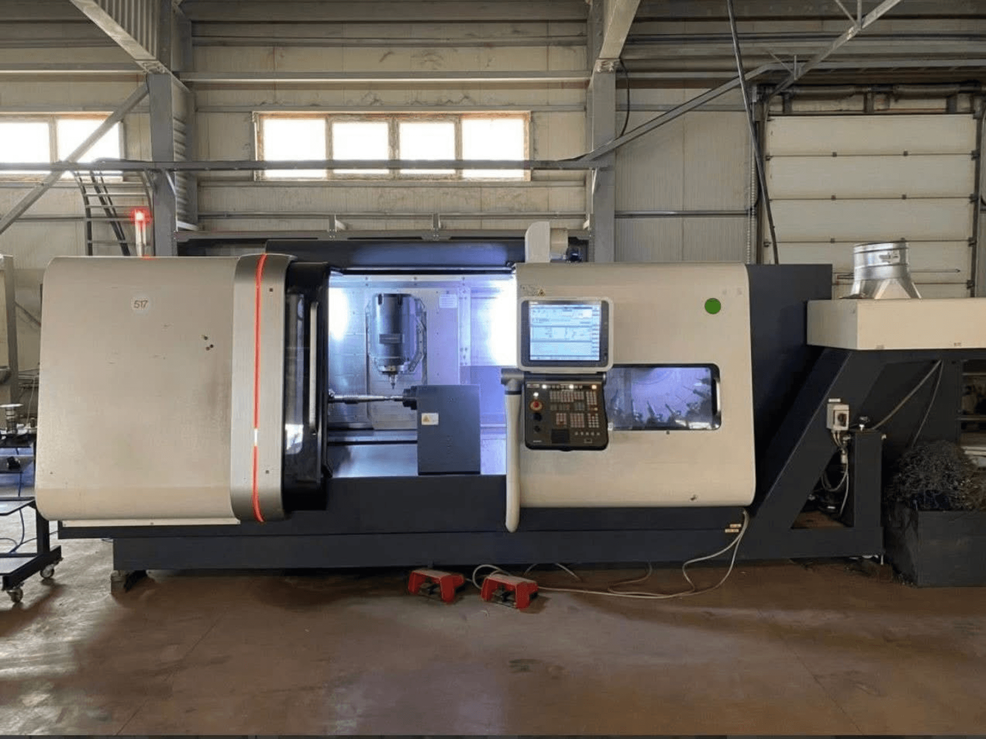 DMG MORI Beta 1250 TC treipingi keskus, esivaade juhtpaneeliga, valgustatud tööruum ja lõiketööriistad nähtavad.