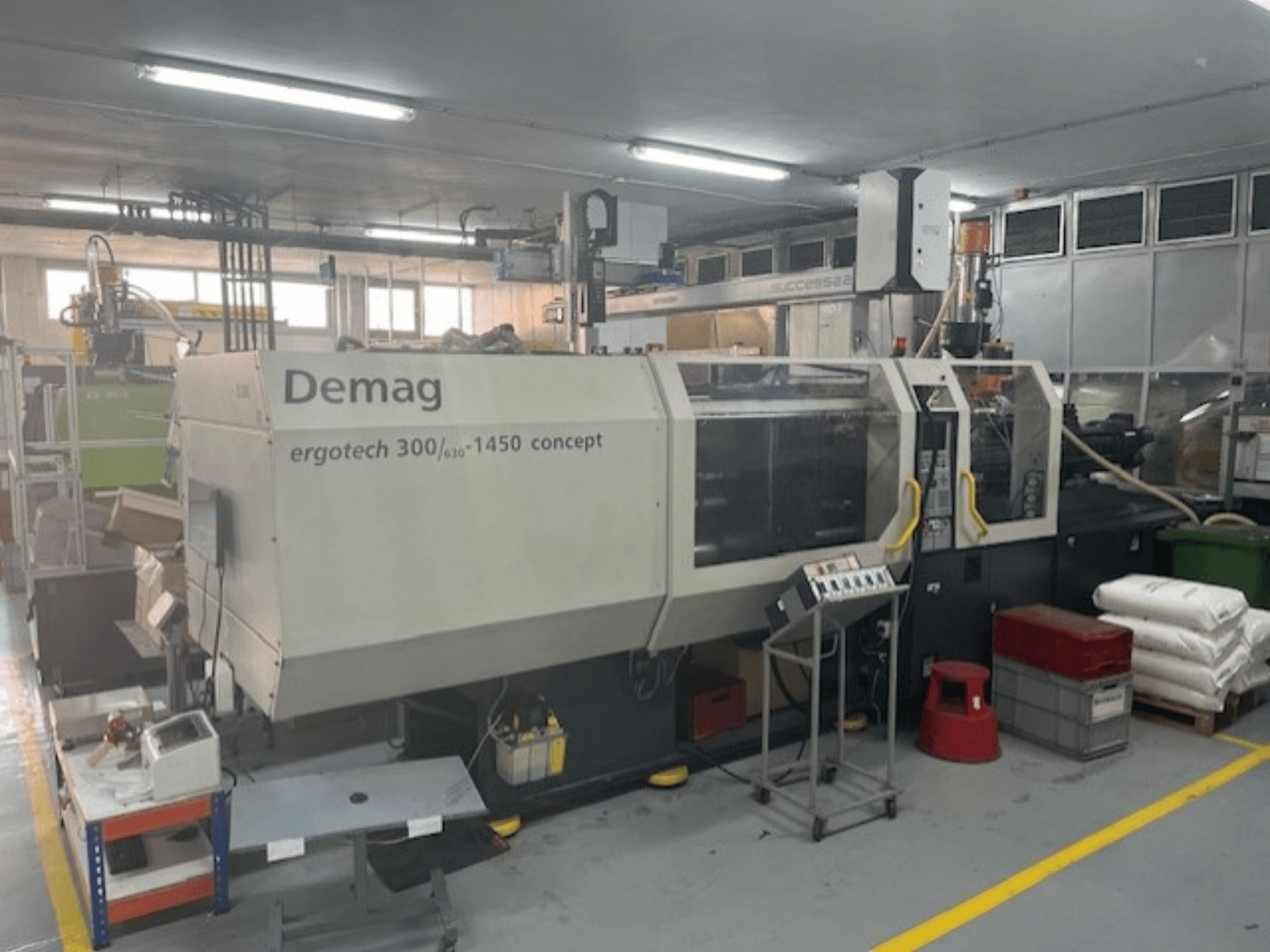 Demag ERGOTECH CONCEPT 3000-1450 hüdrauliline survevalu masin, esiplaanil, koos juhtimisseadmete ja materjalide lähedal.