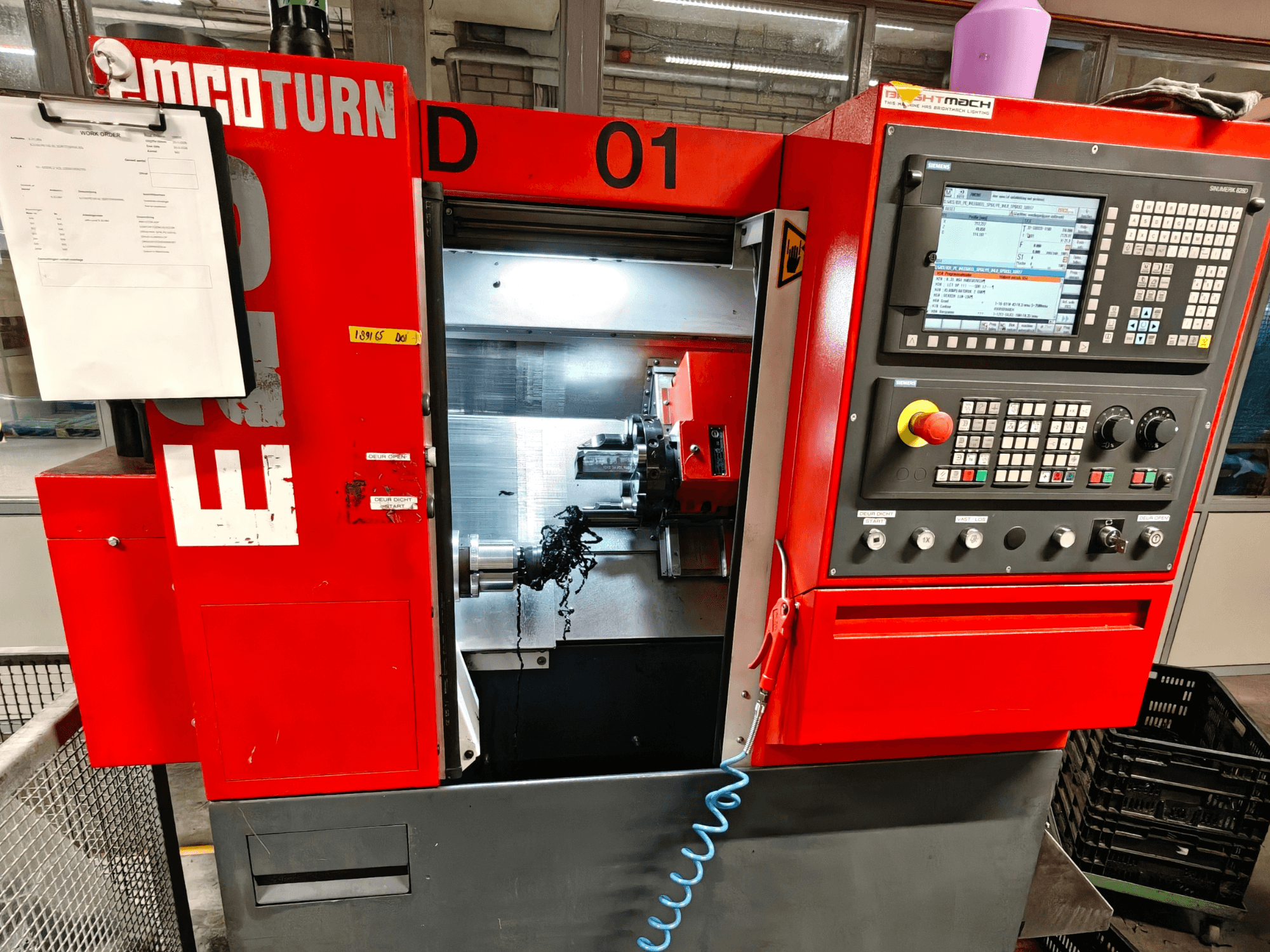 EMCO TURN E25 horisontaalse treipingi esivaade, millel on juhtimisseadmed, tööriistahoidik ja tööala koos laastudega.