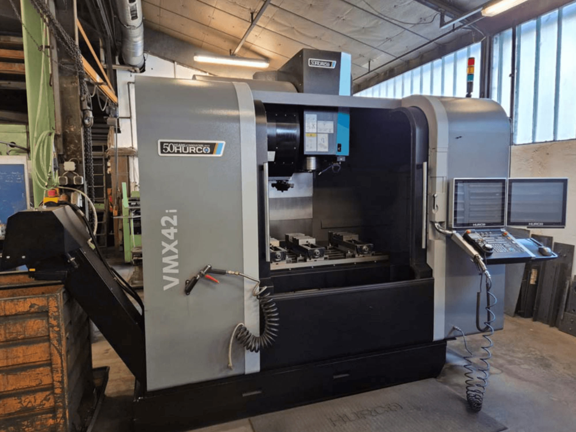 Hurco VMX 42i vertikaalne töötluskeskus, esiplaan, kus on näidatud juhtpaneel ja tööala koos kääridega.