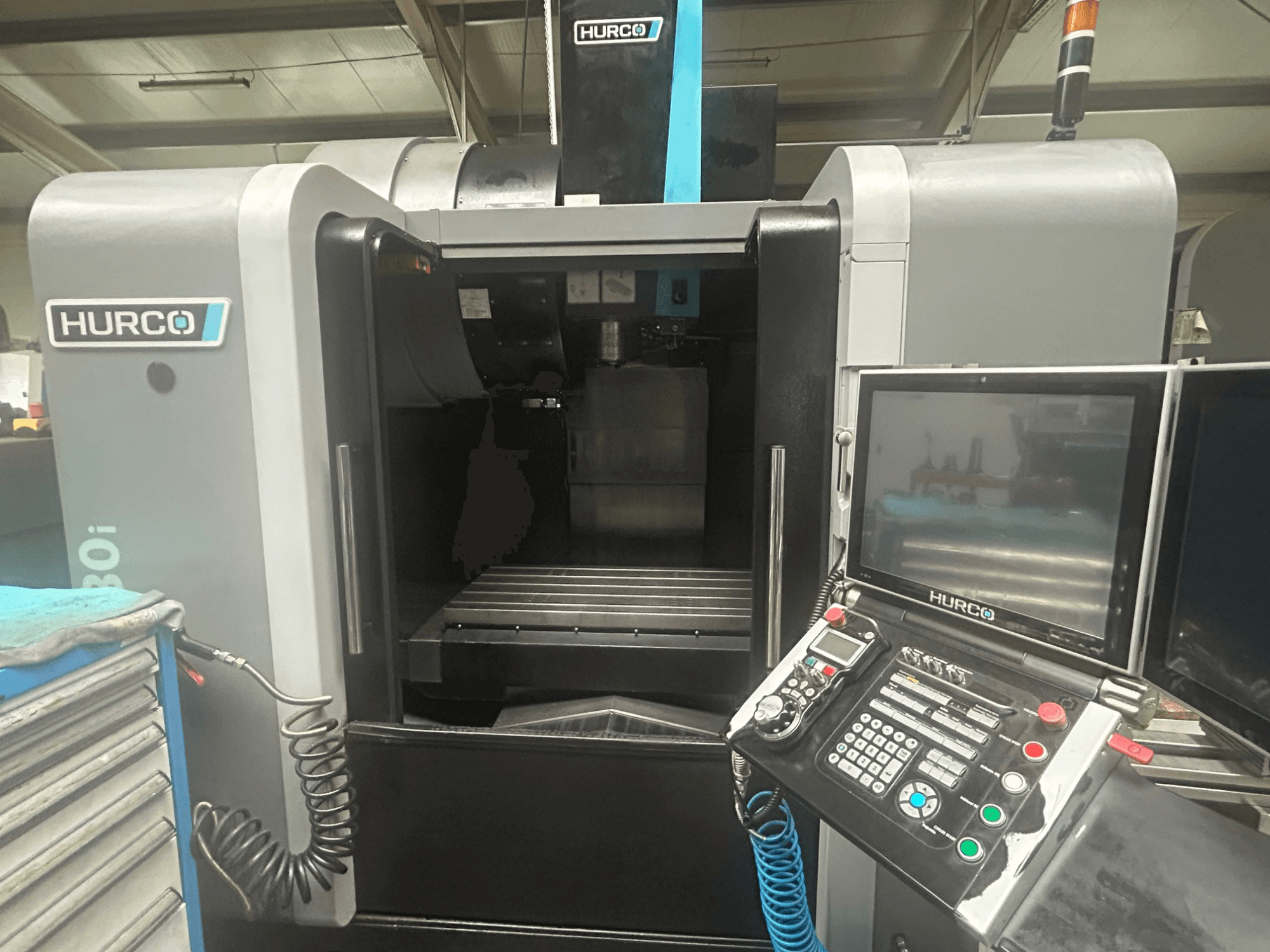 Hurco VM30i CNC-pingi esivaade, millel on juhtpaneel koos nuppude, ekraani ja tööriistade hoiuruumiga.