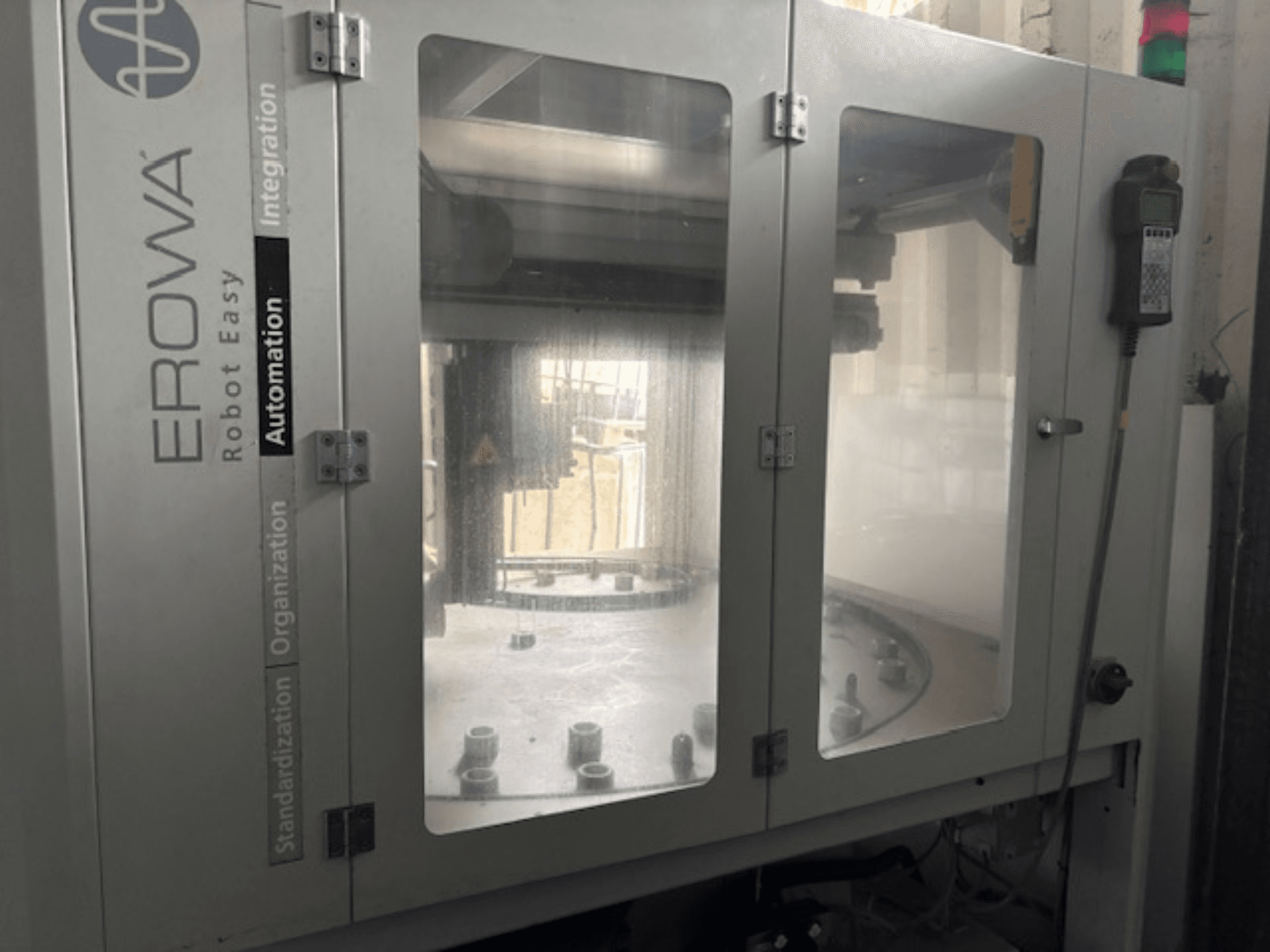 EROWA Robot Easy Automationi esivaade; läbipaistvad uksed, nähtavad automaatikakomponendid ja juhtpaneel.
